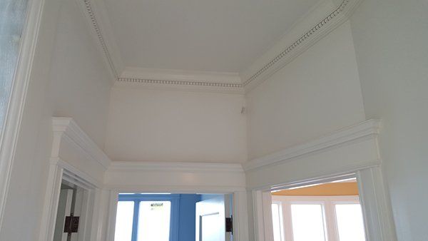 A hallway with a white ceiling and a blue wall