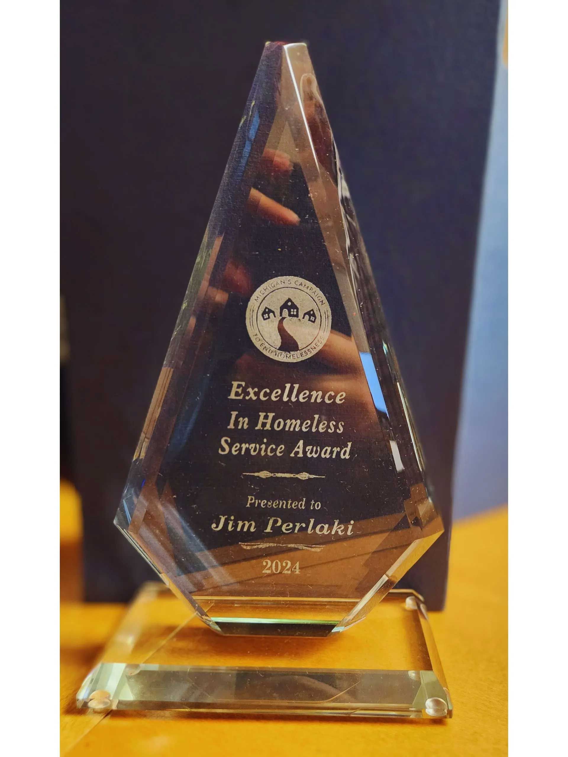 Glass award: Excellence in Homeless Service Award, presented to Jim Perlant, on a table.
