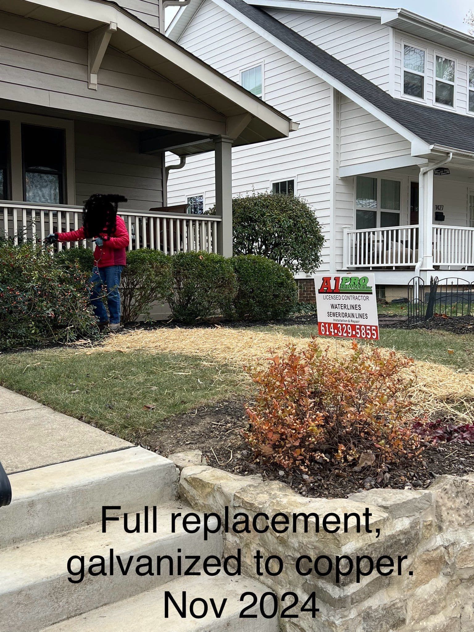 Person tending garden in front of a house. Sign: 