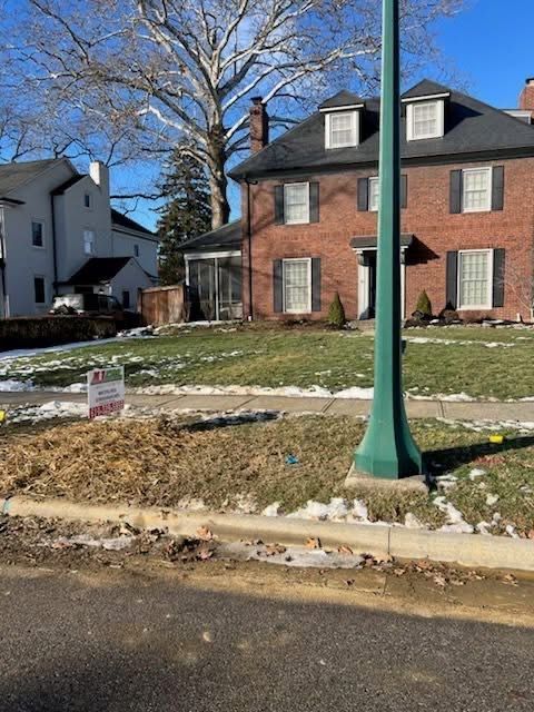 Brick house with green lawn and a street lamp.