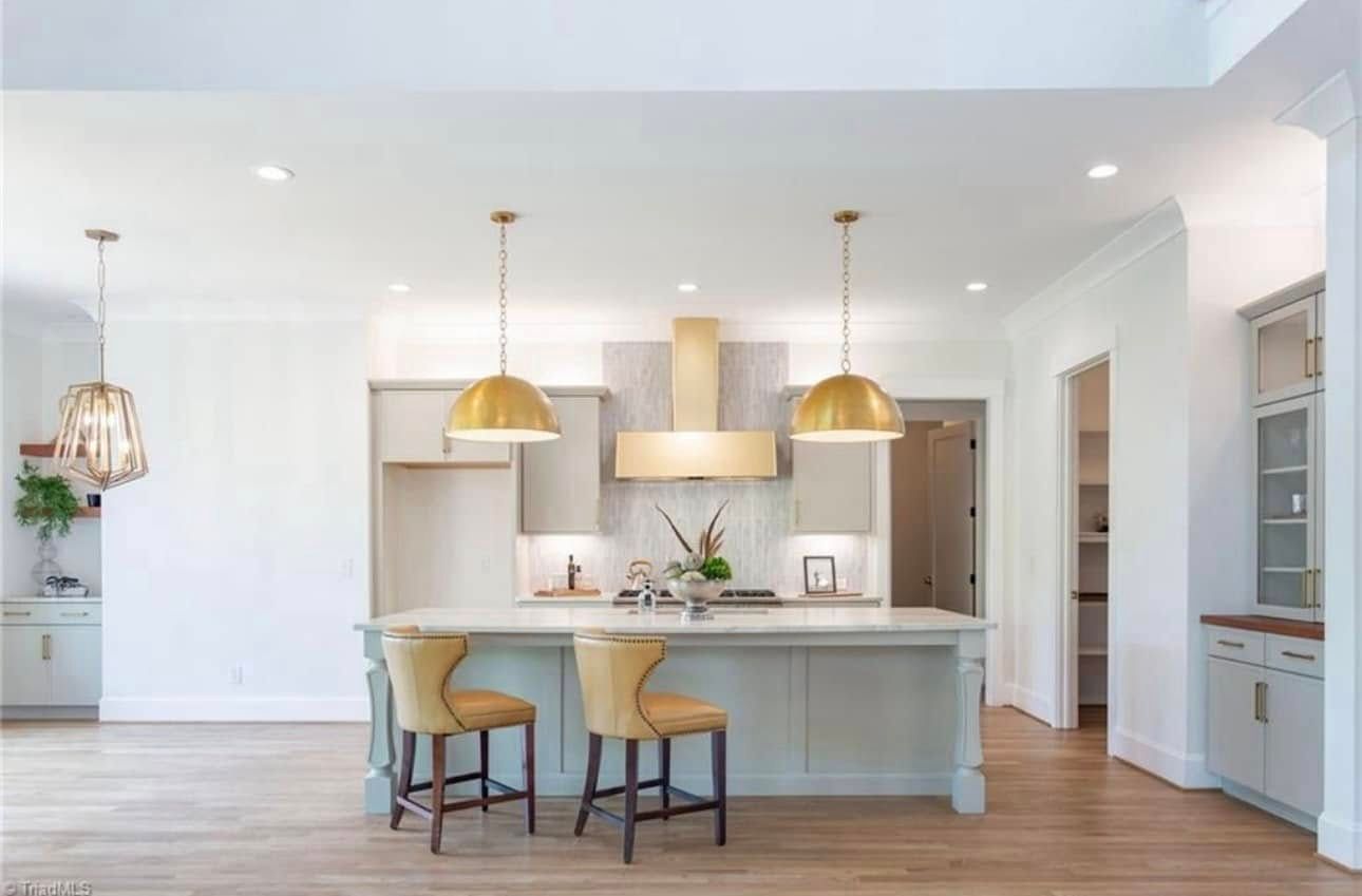 A kitchen with a large island and two stools.