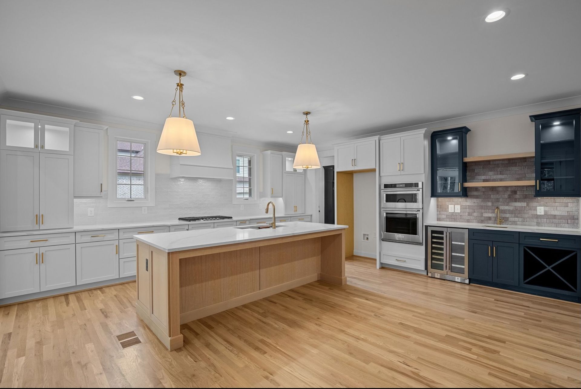 A kitchen with white cabinets and a stove top oven