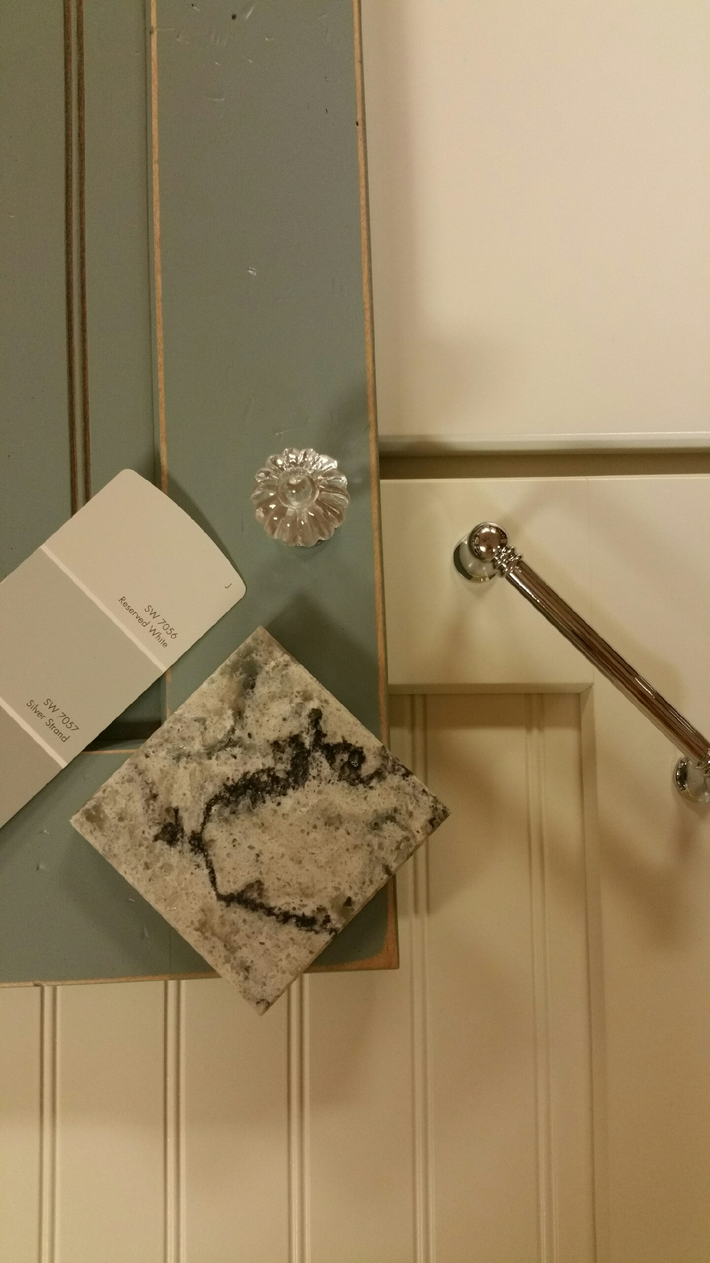 A bathroom with a marble counter top , a sink , and a door.