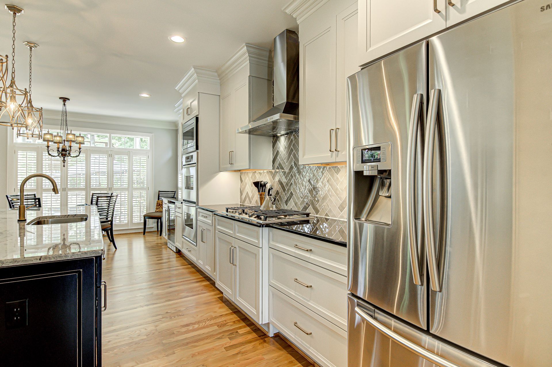 A kitchen with stainless steel appliances and white cabinets.