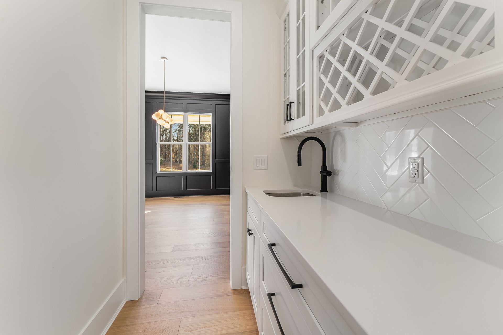 A kitchen with white cabinets and a wine rack on the wall.