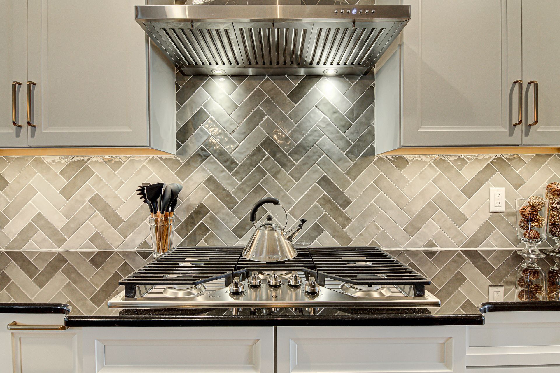 A kitchen with a stove top oven and a hood above it.