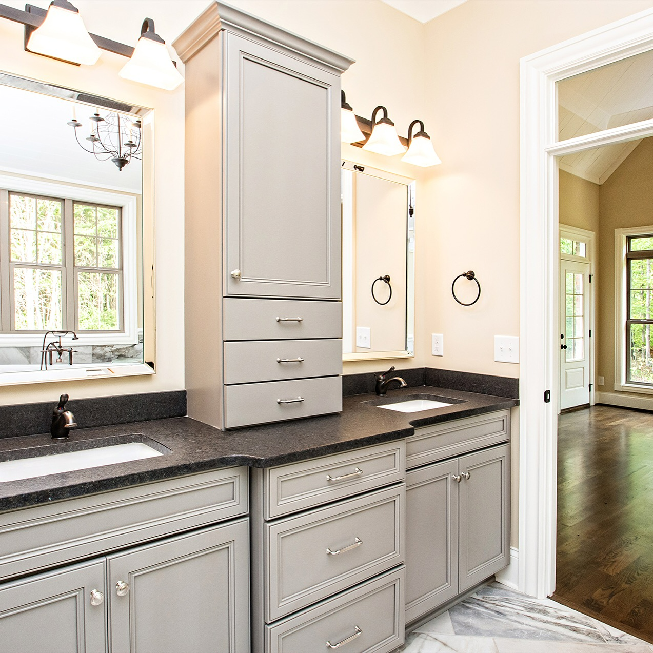 A bathroom with gray cabinets , a sink and a mirror