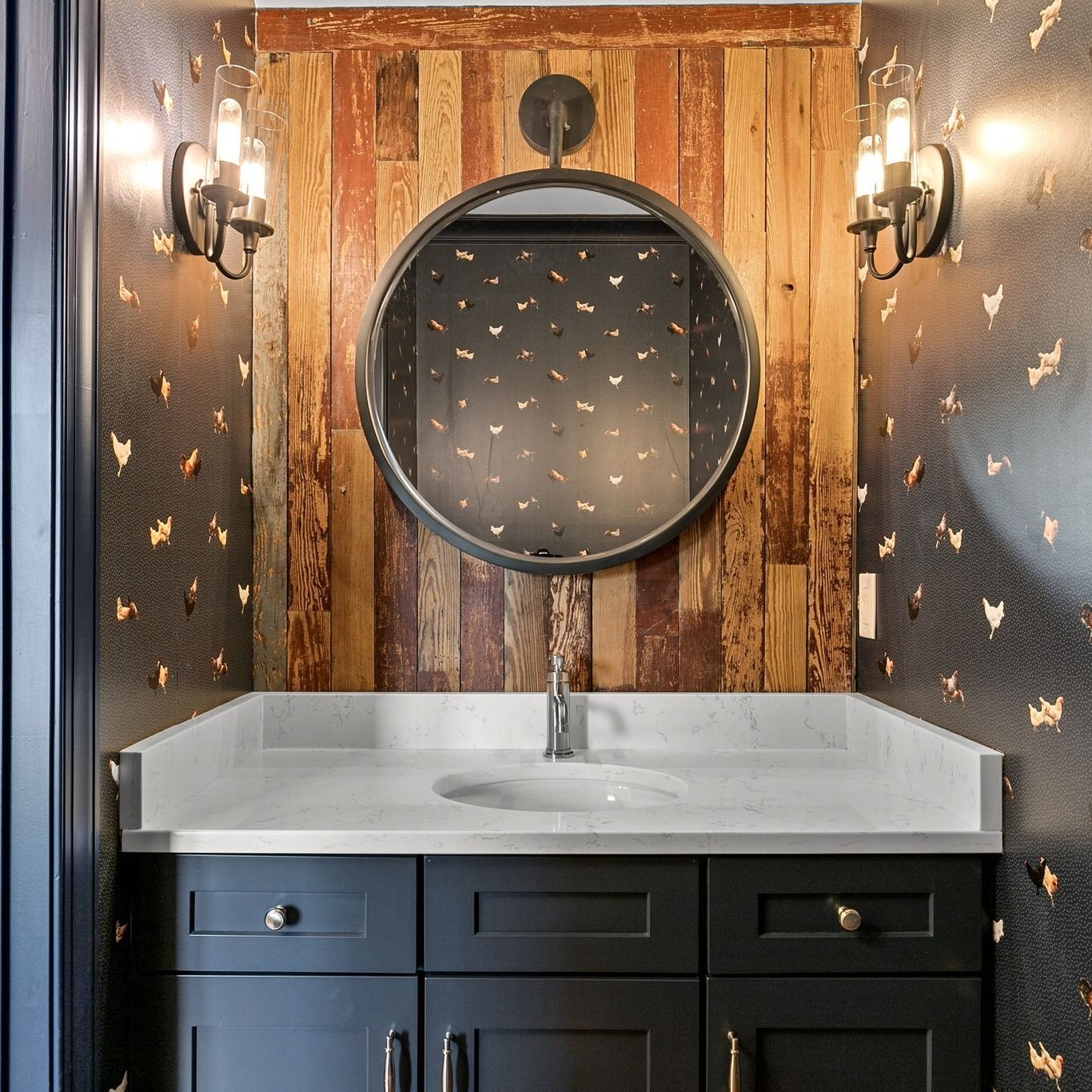 A bathroom with a sink and a round mirror