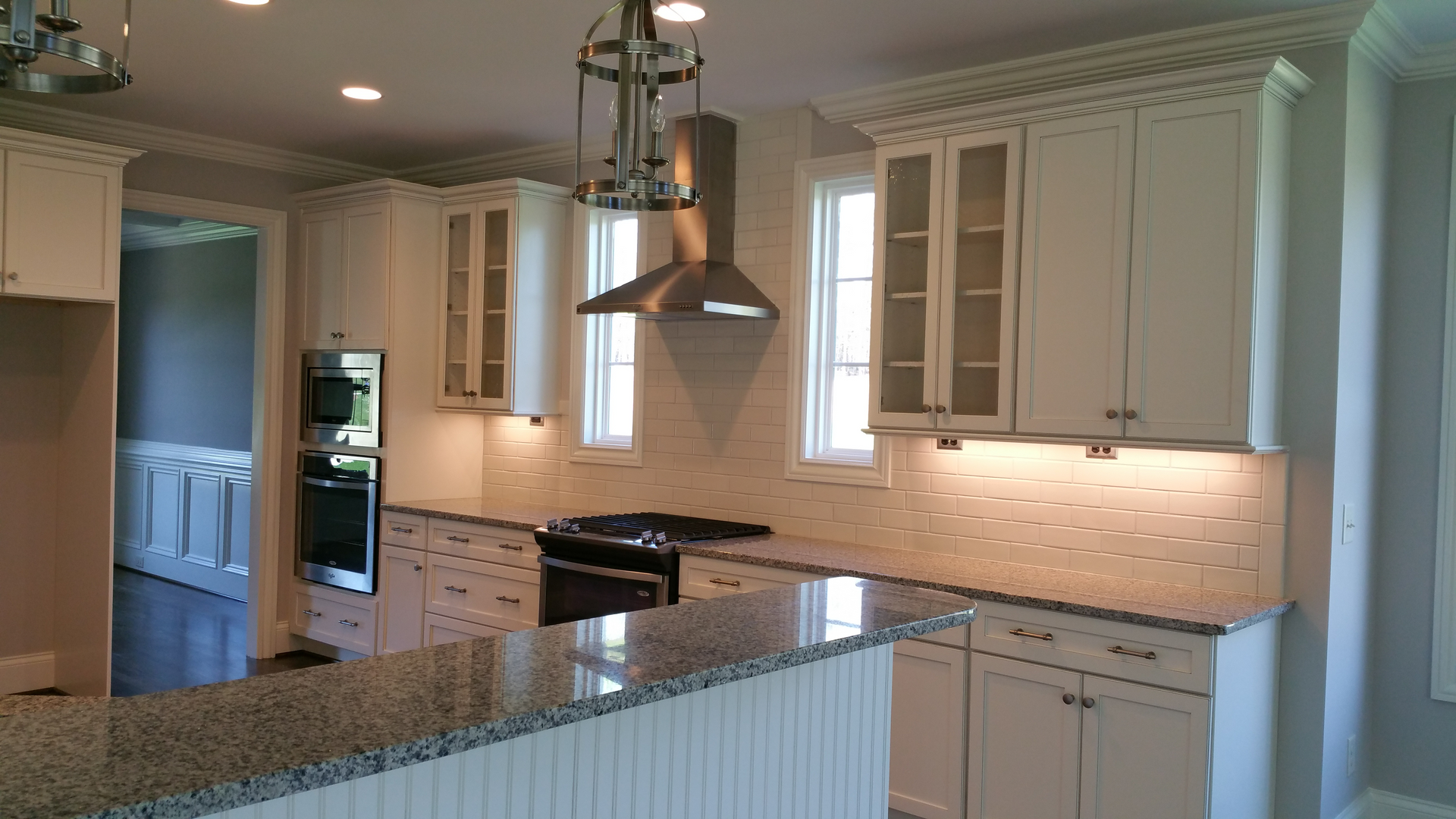 A kitchen with white cabinets and granite counter tops