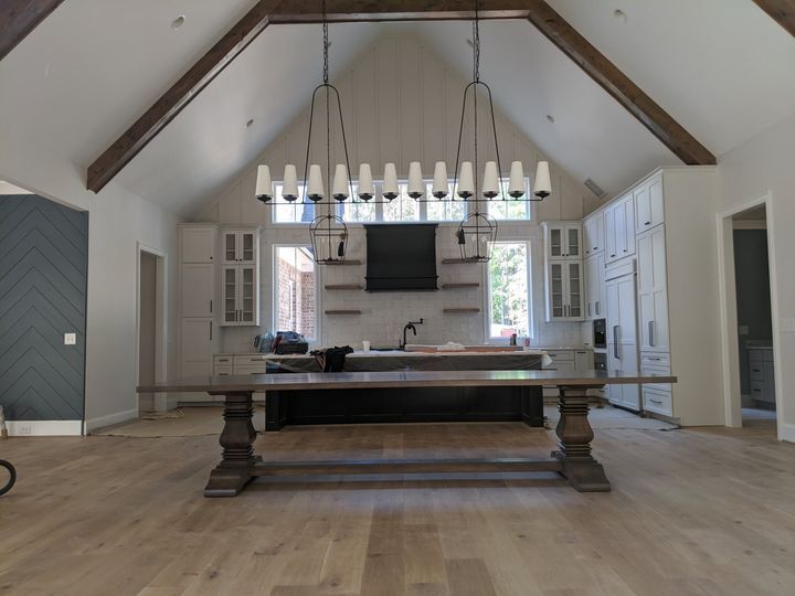 A kitchen with a large table and a chandelier hanging from the ceiling