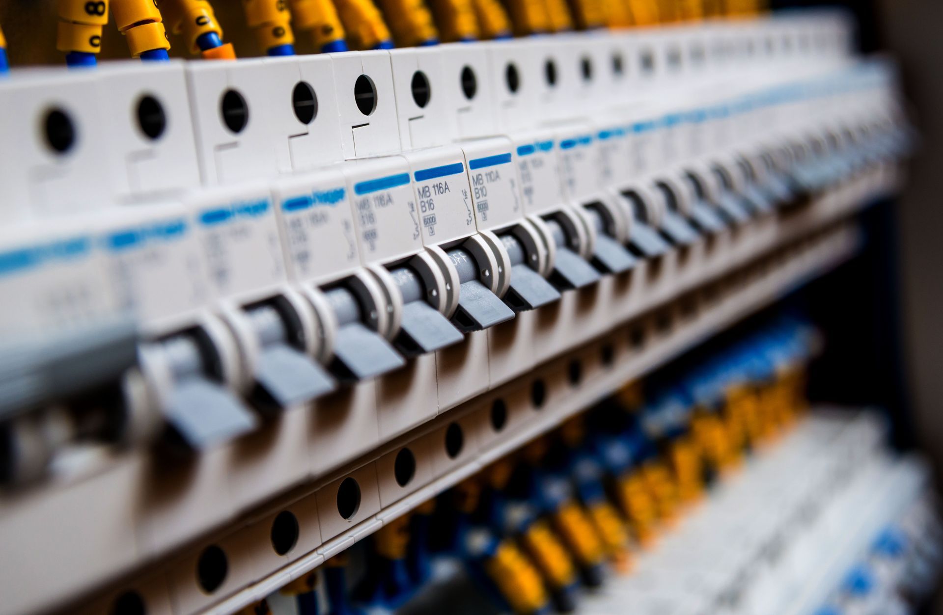 Row of electrical circuit breakers, mostly on, with wires and details visible.