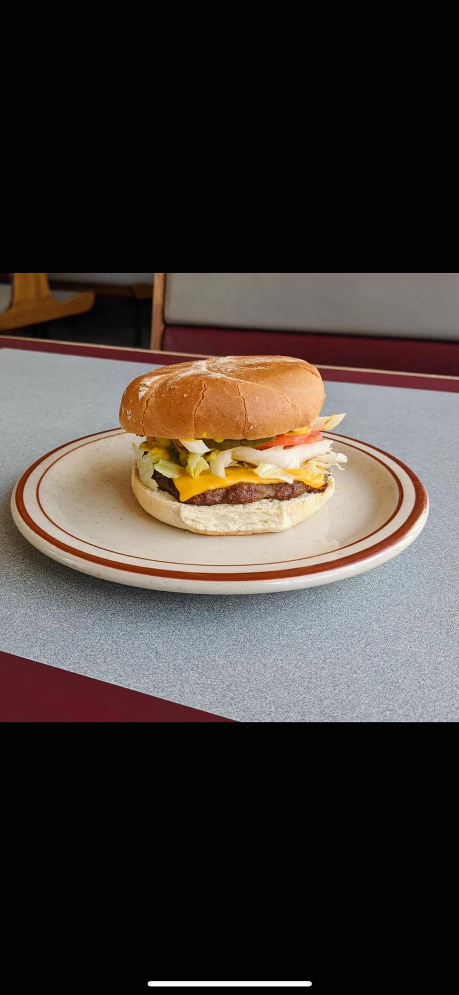 A hamburger is on a plate on a table.