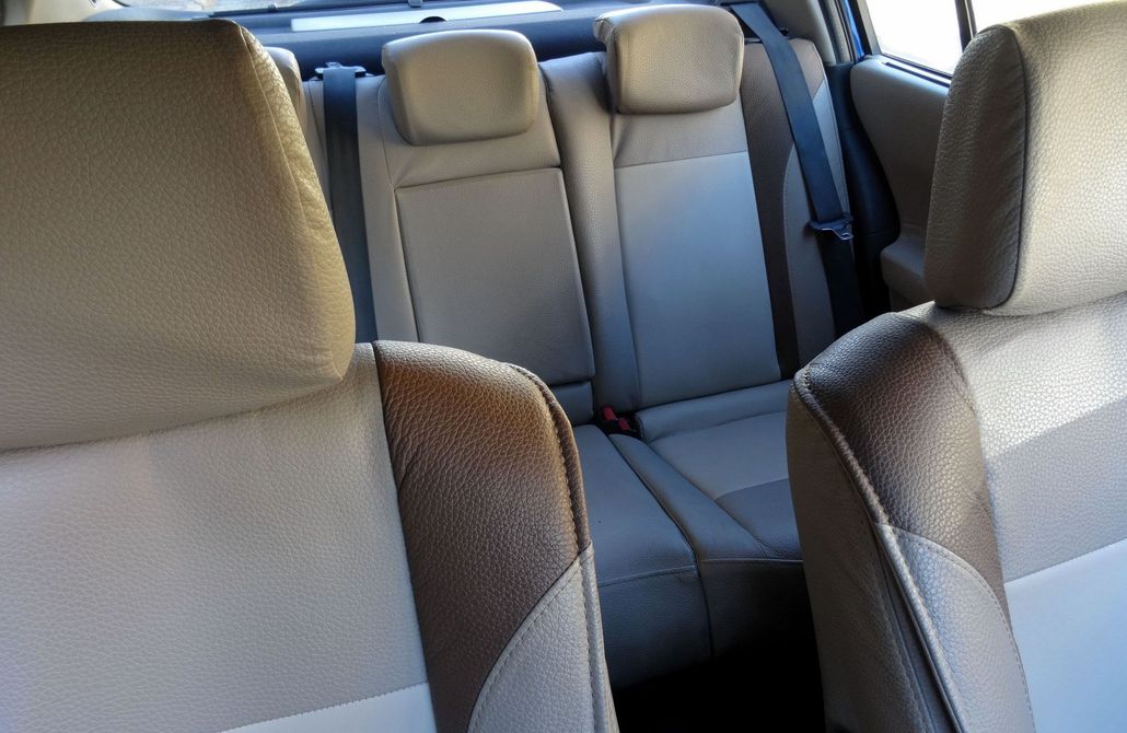 Car interior with gray fabric seats and front headrests, viewed from the back seat.