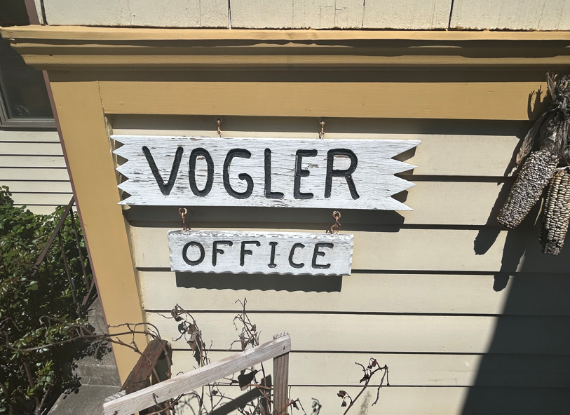 Vogler office sign on a beige building exterior, with black letters on white boards.