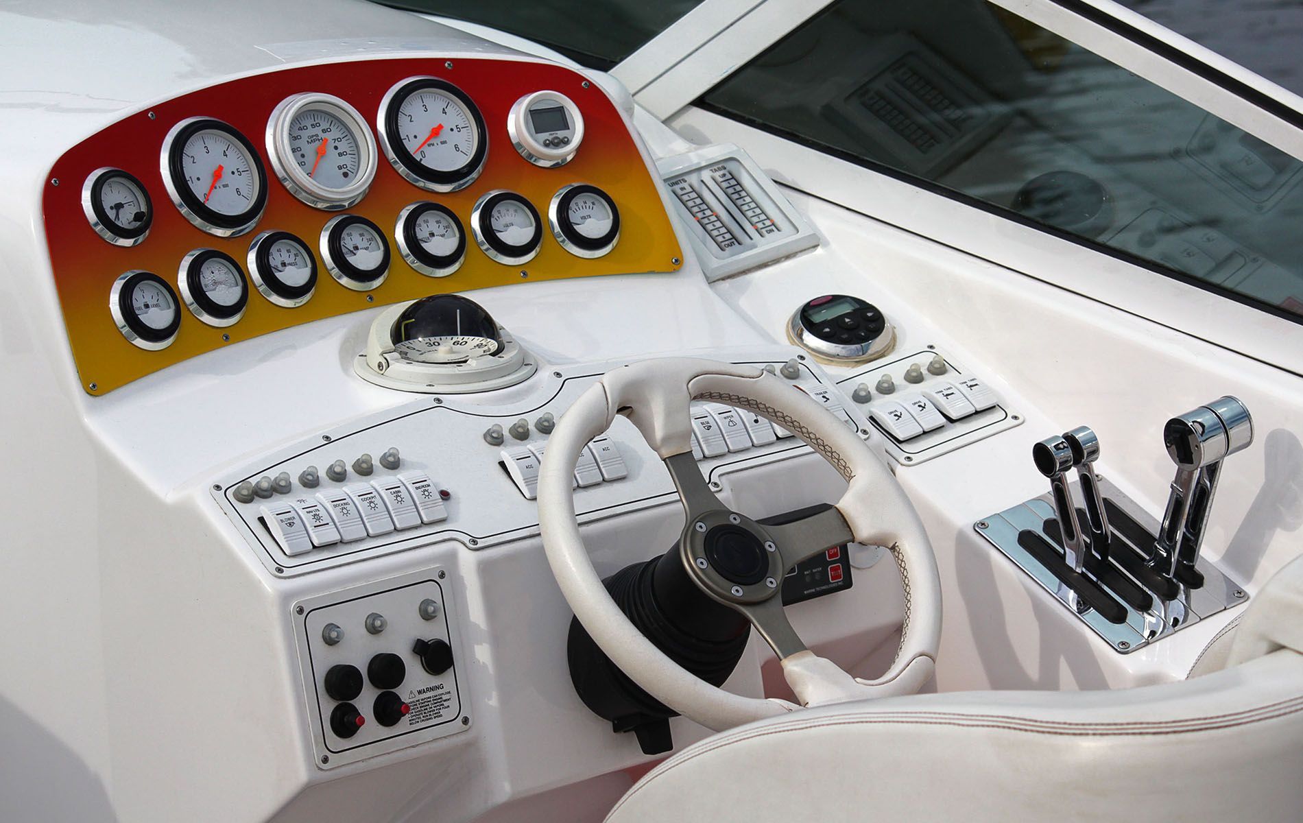 A man is driving a boat at sunset.