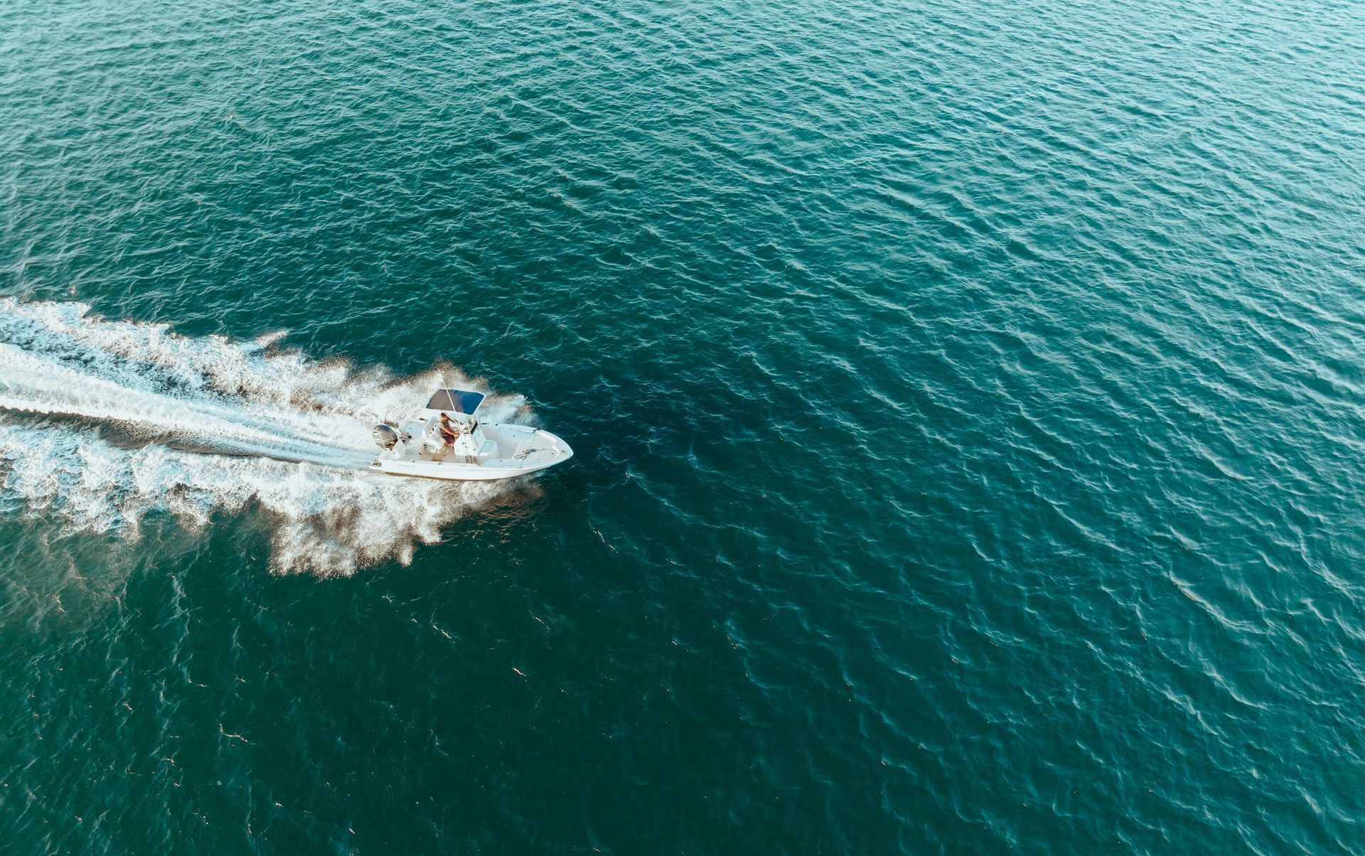 A white boat is floating on top of a body of water.