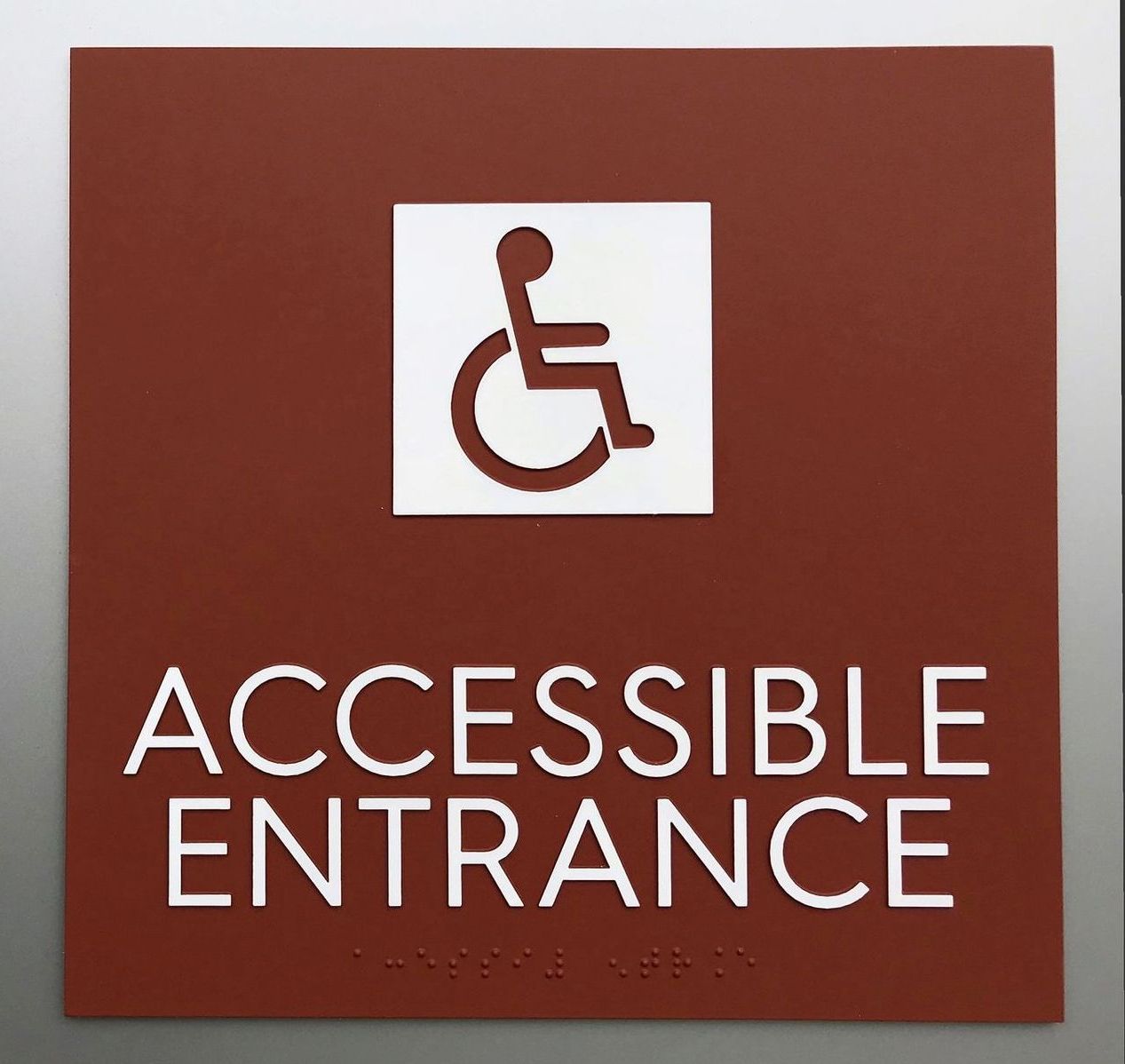A sign that says accessible entrance with a picture of a person in a wheelchair