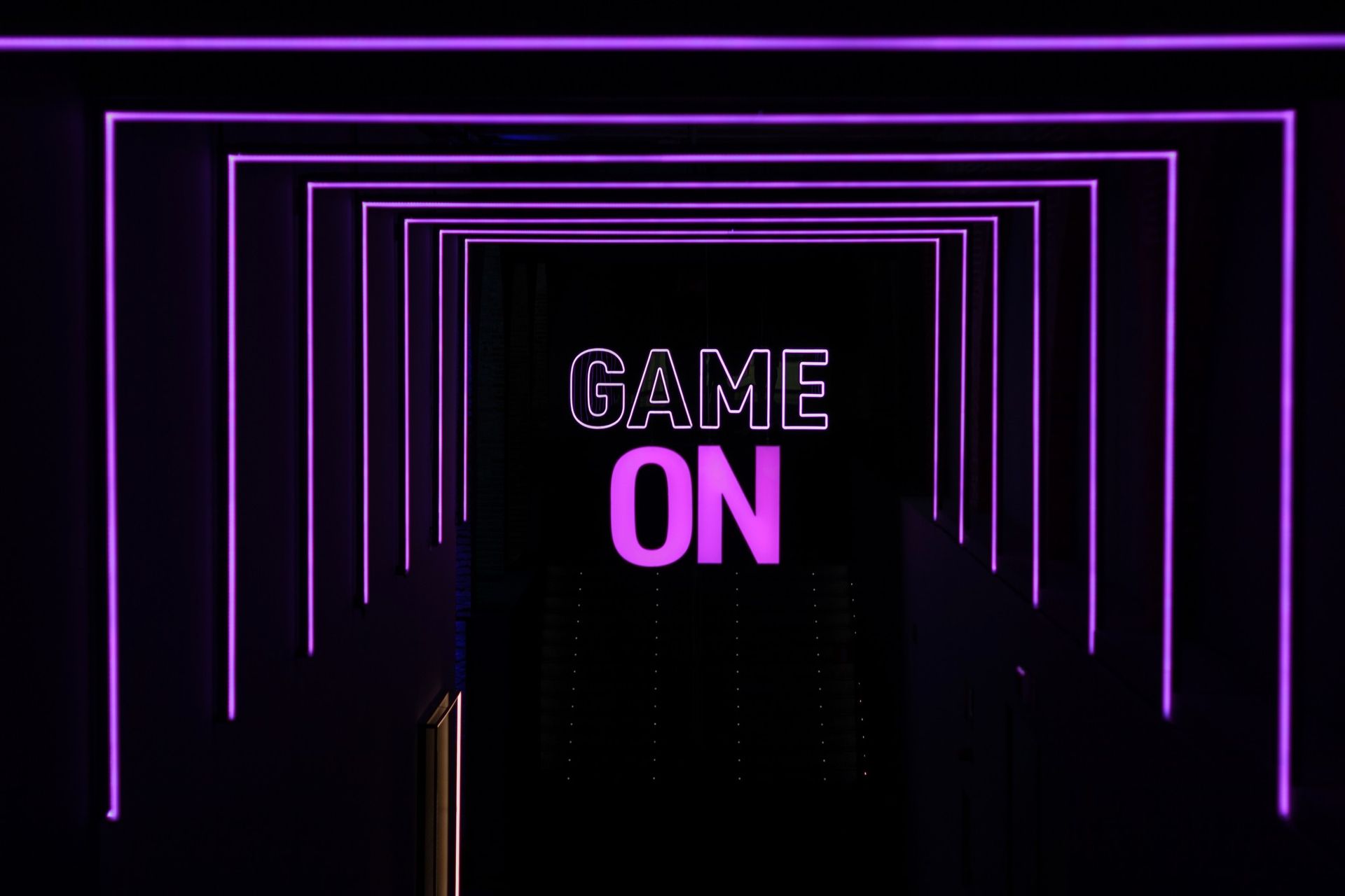 A neon sign that says `` game on '' on a black background.