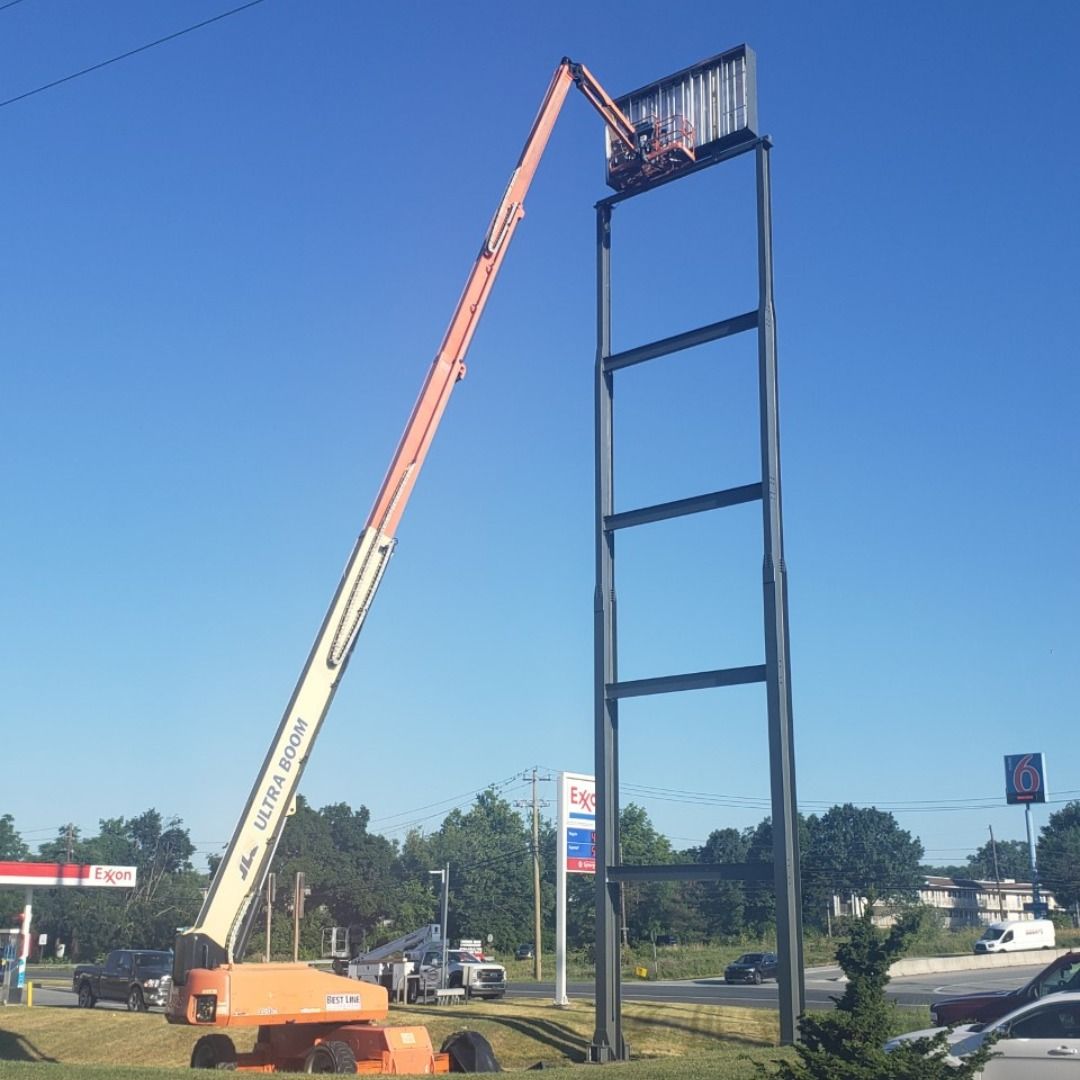 A jlg crane is lifting a large sign