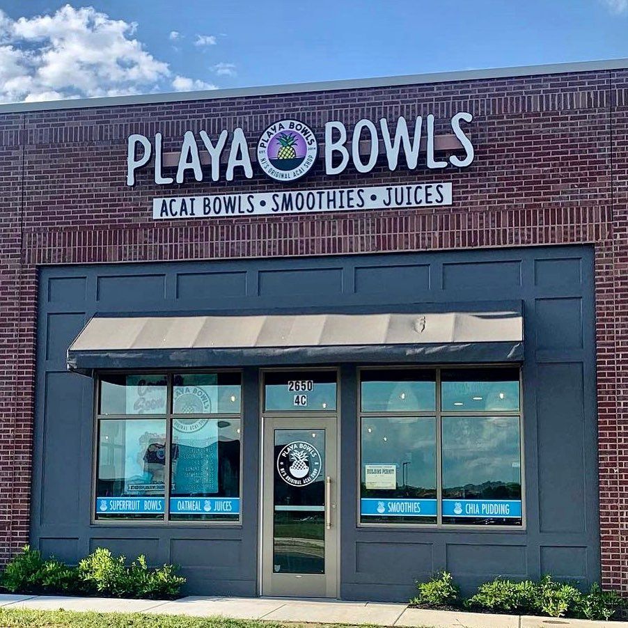 A brick building with a sign that says playa bowls