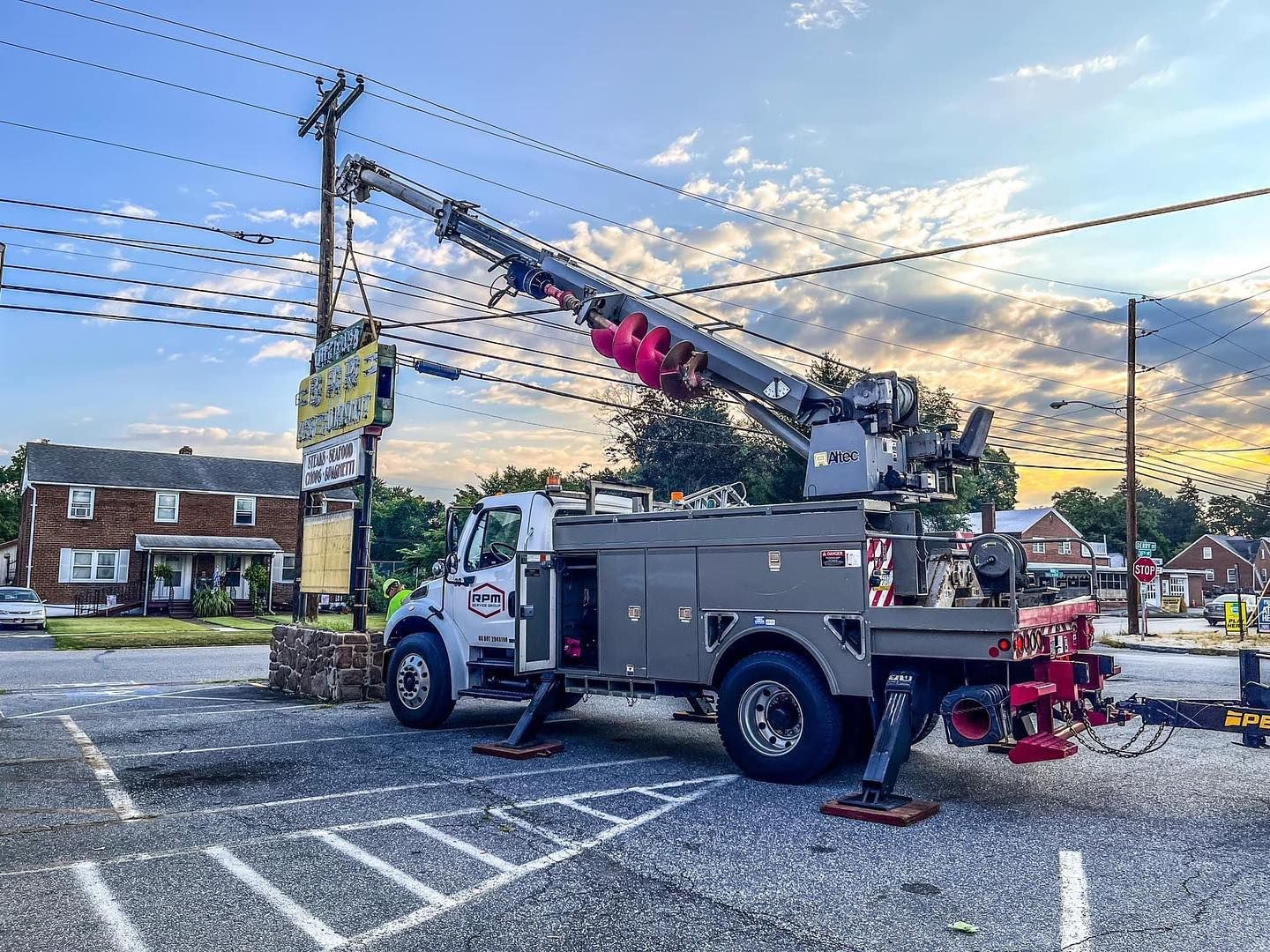 A truck with a crane on top of it is parked in a parking lot.
