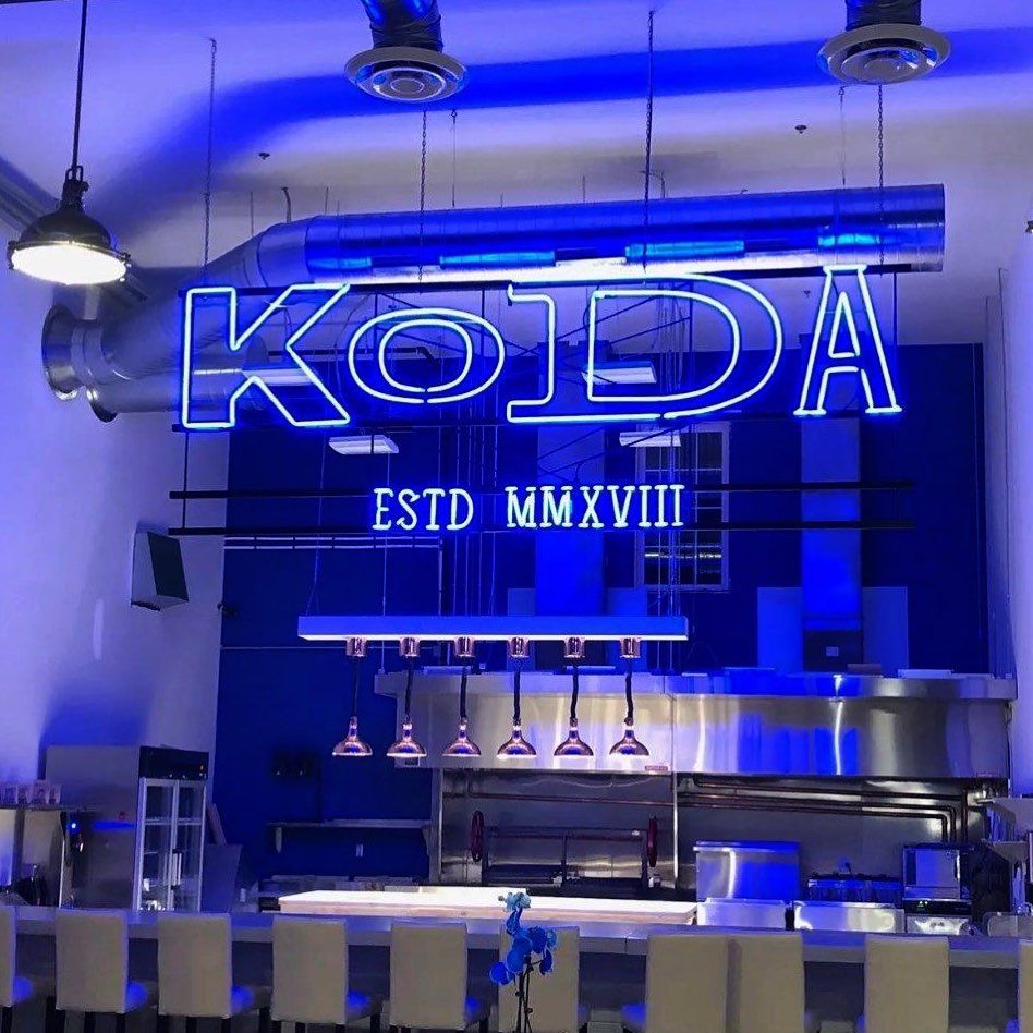A restaurant with a neon sign that says koda