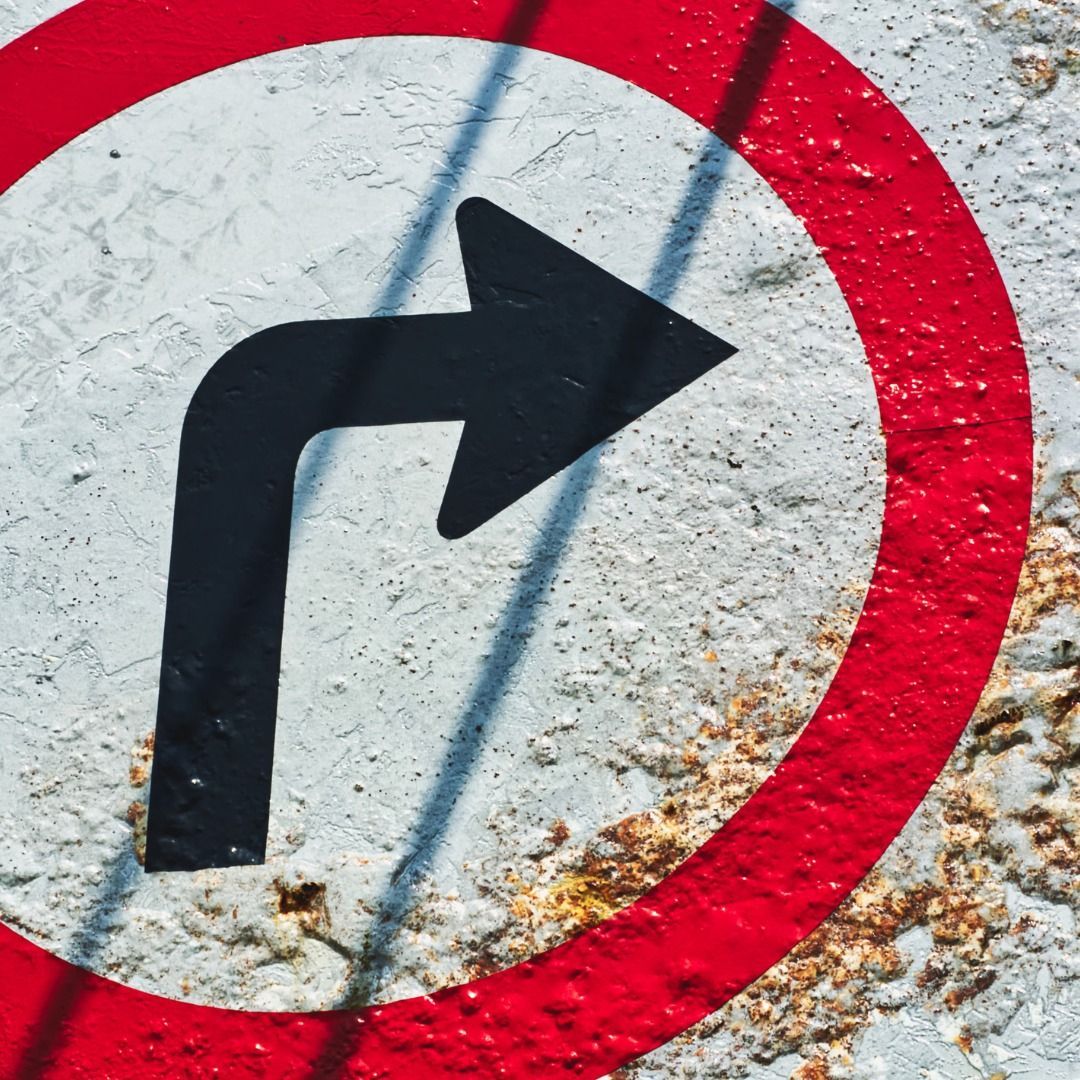 A red and white sign with an arrow pointing to the right