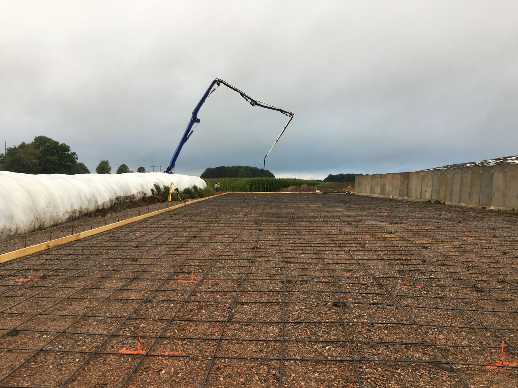 A concrete pump is being used to pour concrete on a road