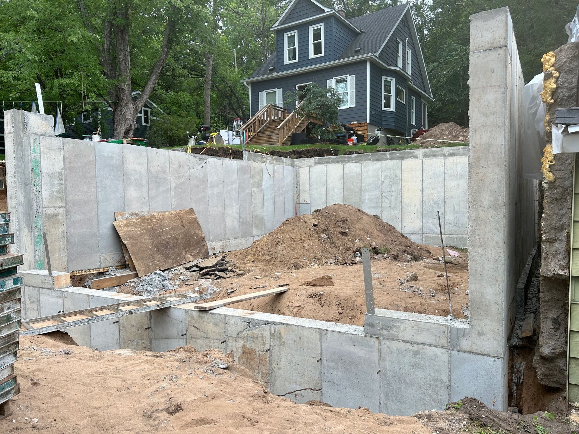 A concrete wall is being built in front of a house.