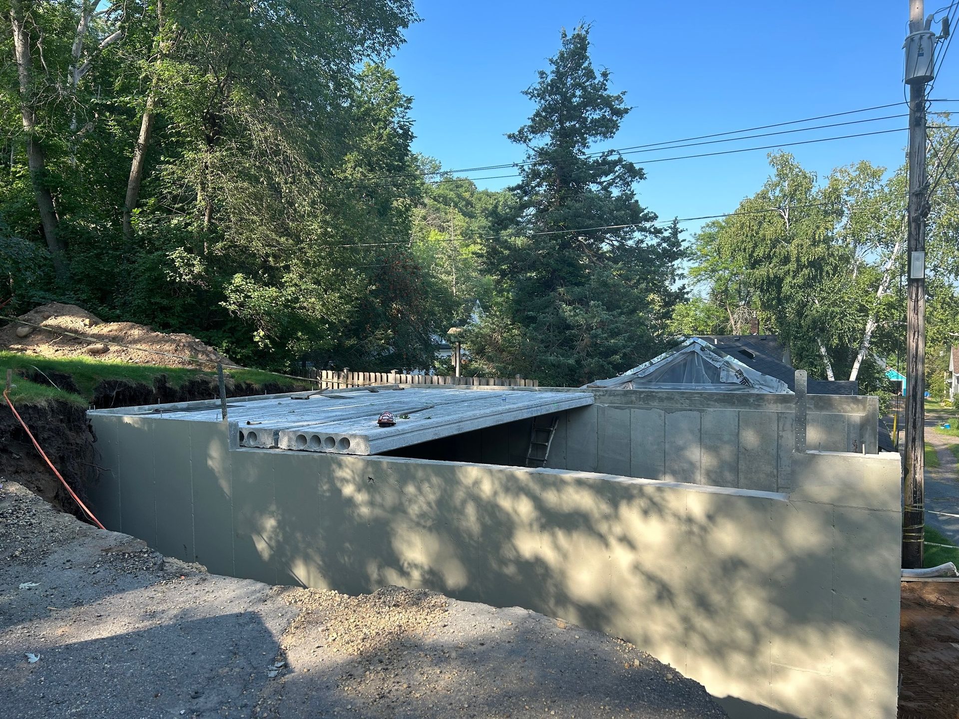 A concrete wall is being built in front of a house.