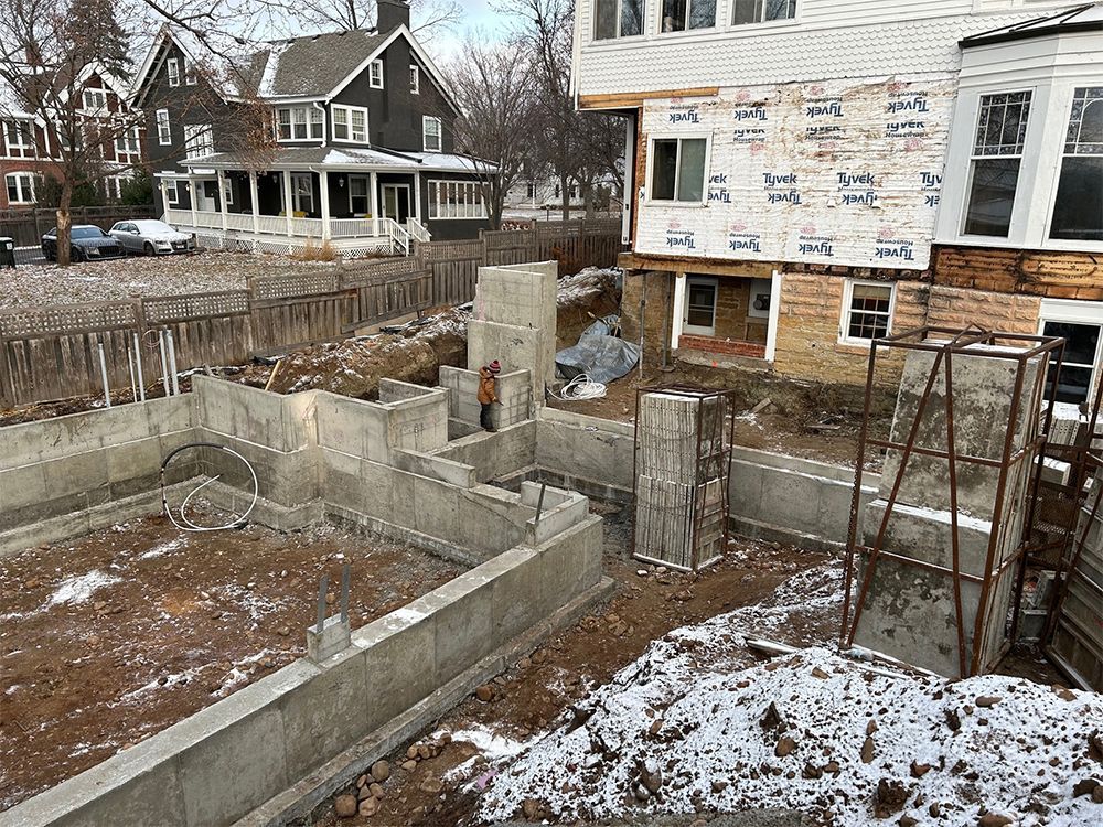 A house is being built in a snowy neighborhood.