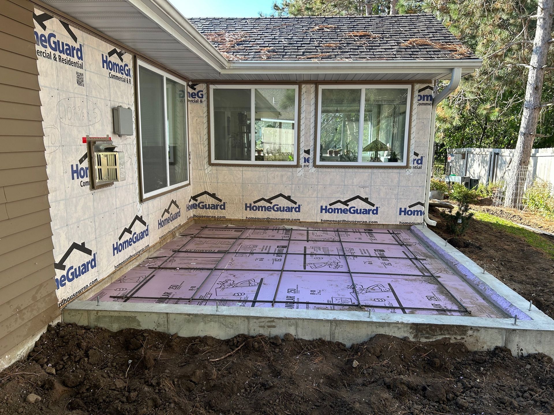 A patio is being built in the backyard of a house.