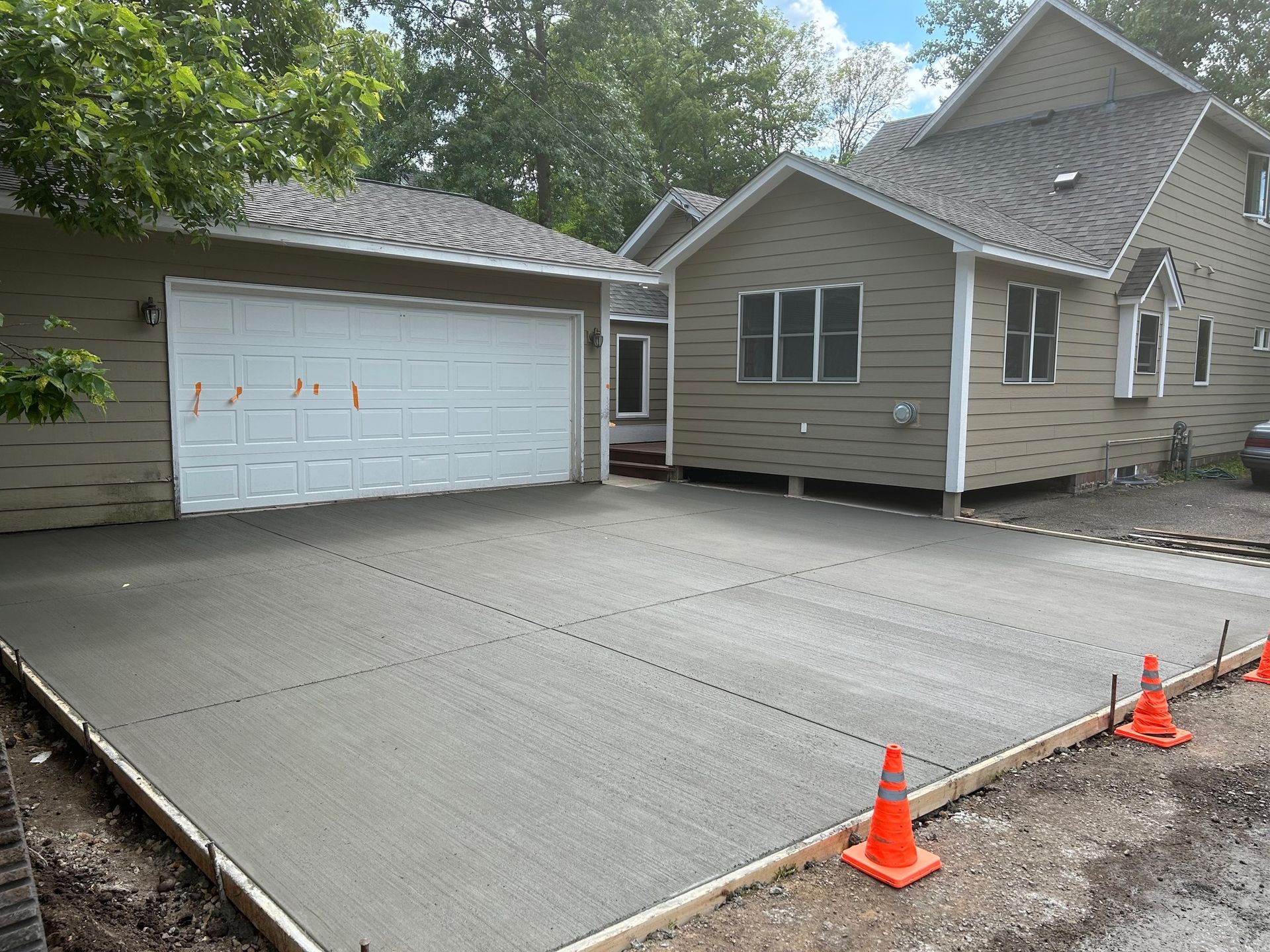 A concrete driveway is being built in front of a house.
