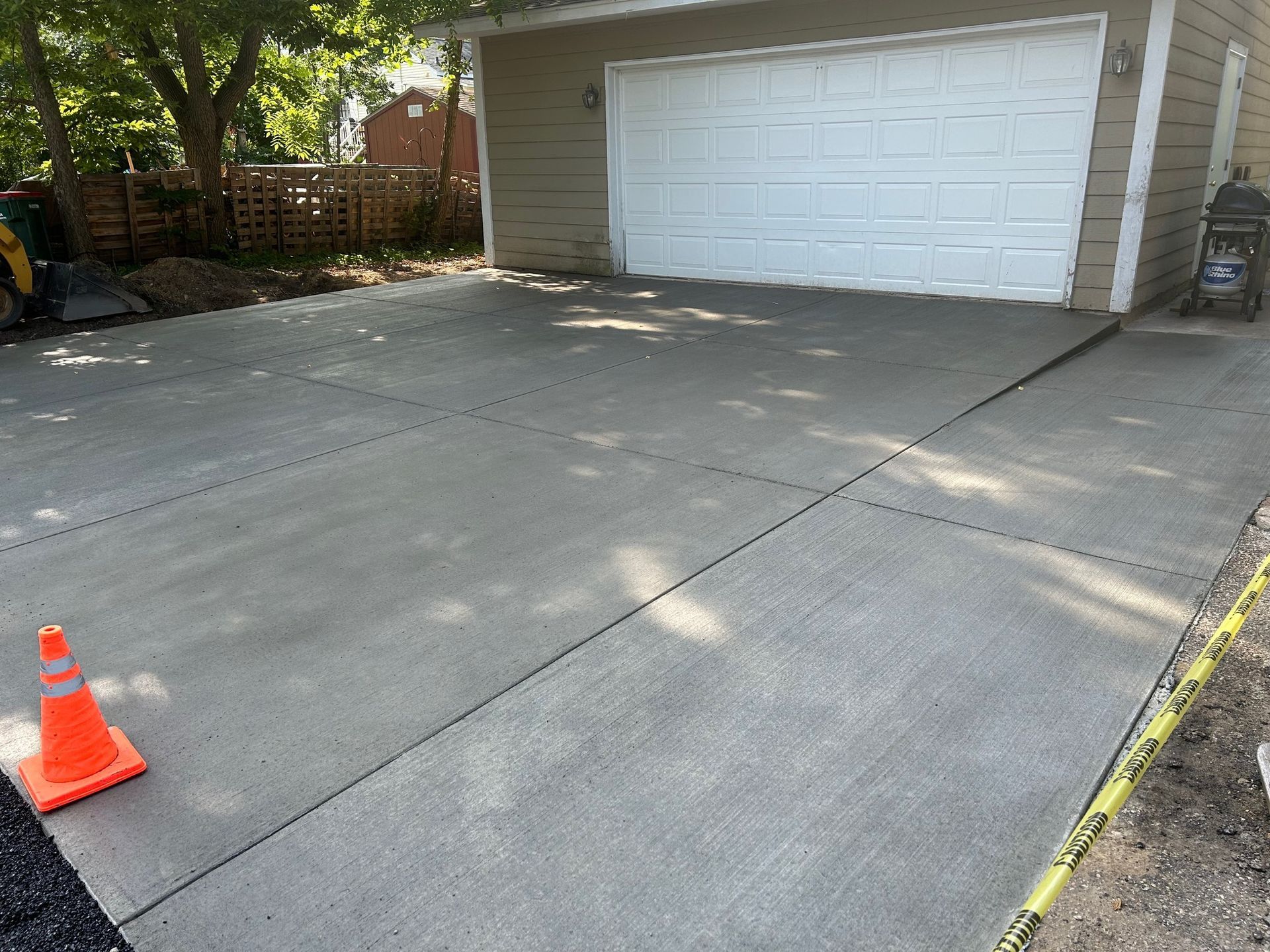 A concrete driveway is being built in front of a garage.