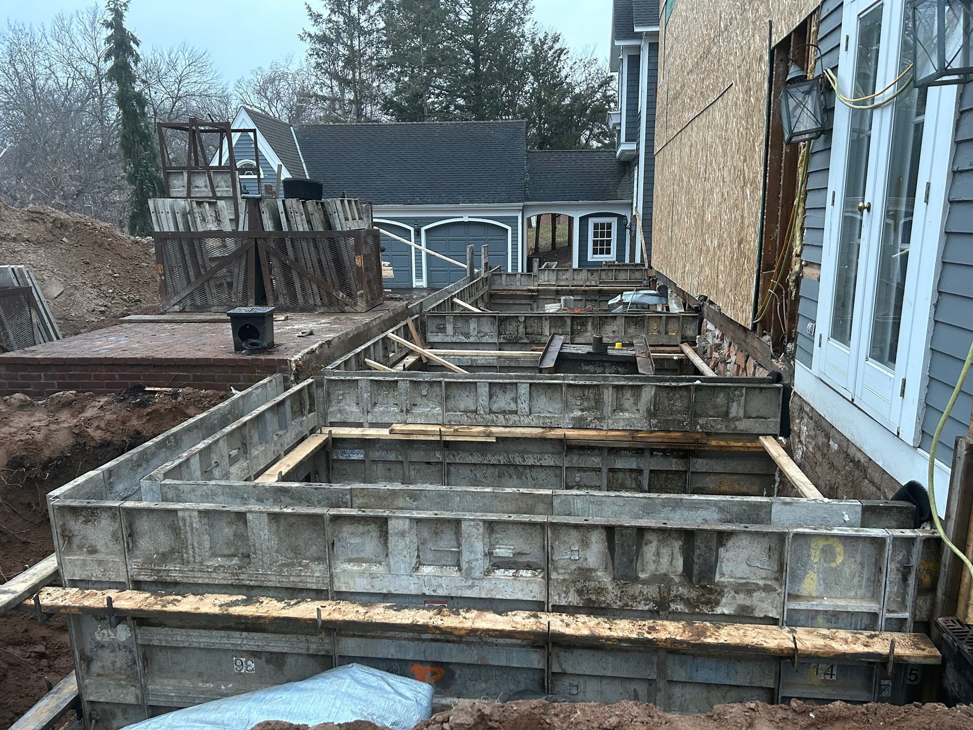 A concrete foundation is being built in front of a house.