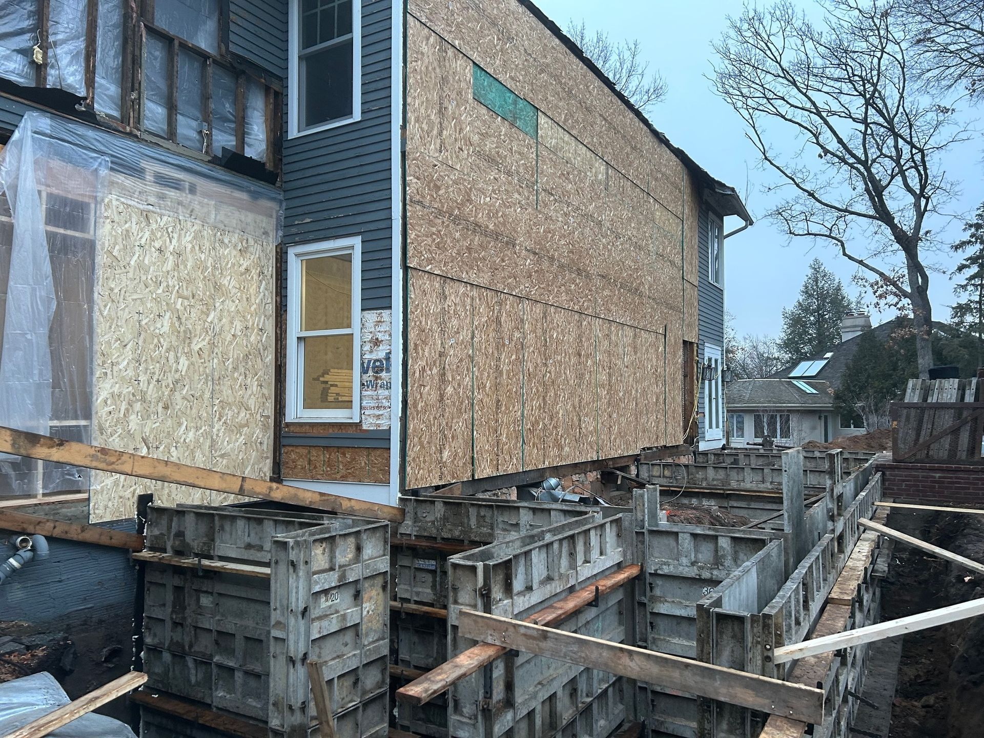A house is being built with a lot of wooden boxes in front of it.