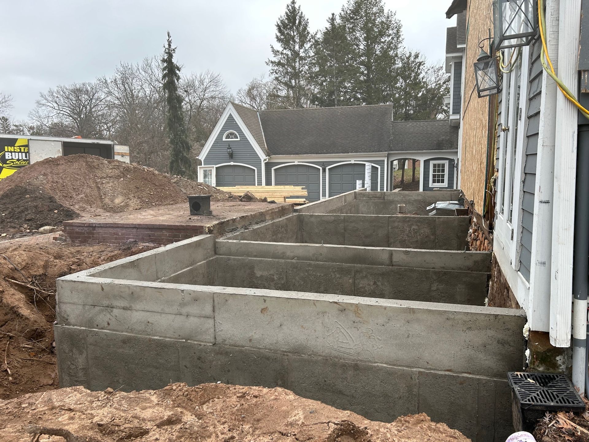 A concrete foundation is being built in front of a house.