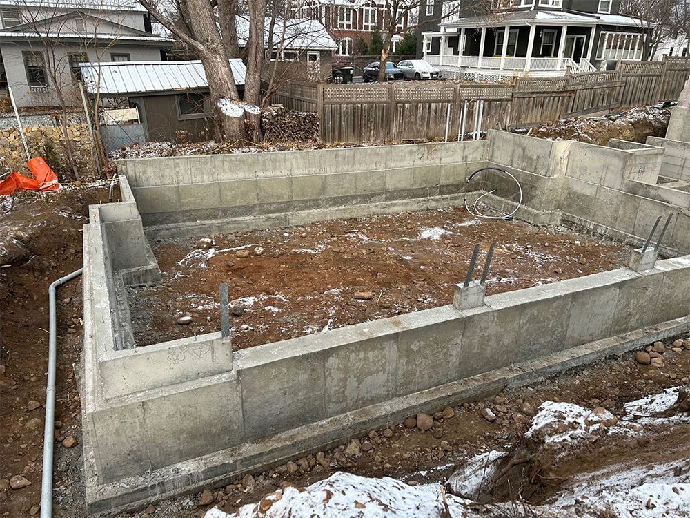 A concrete foundation for a house is being built in the snow.