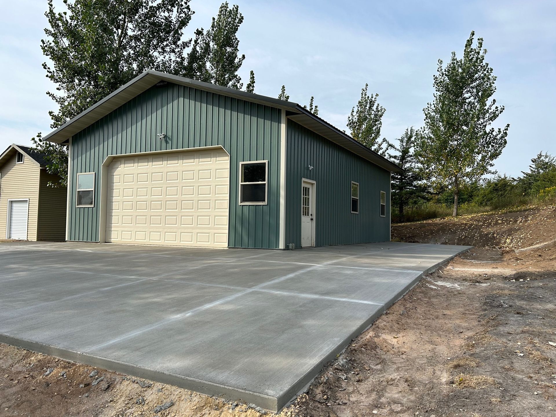 A garage with a concrete driveway in front of it
