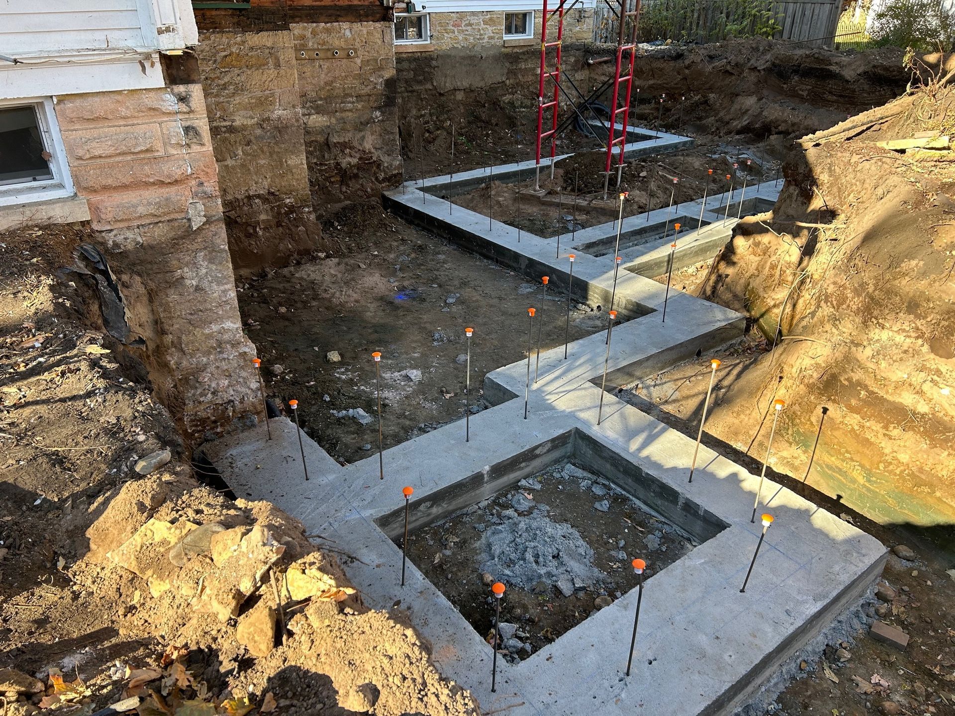 A concrete foundation is being built in front of a house.