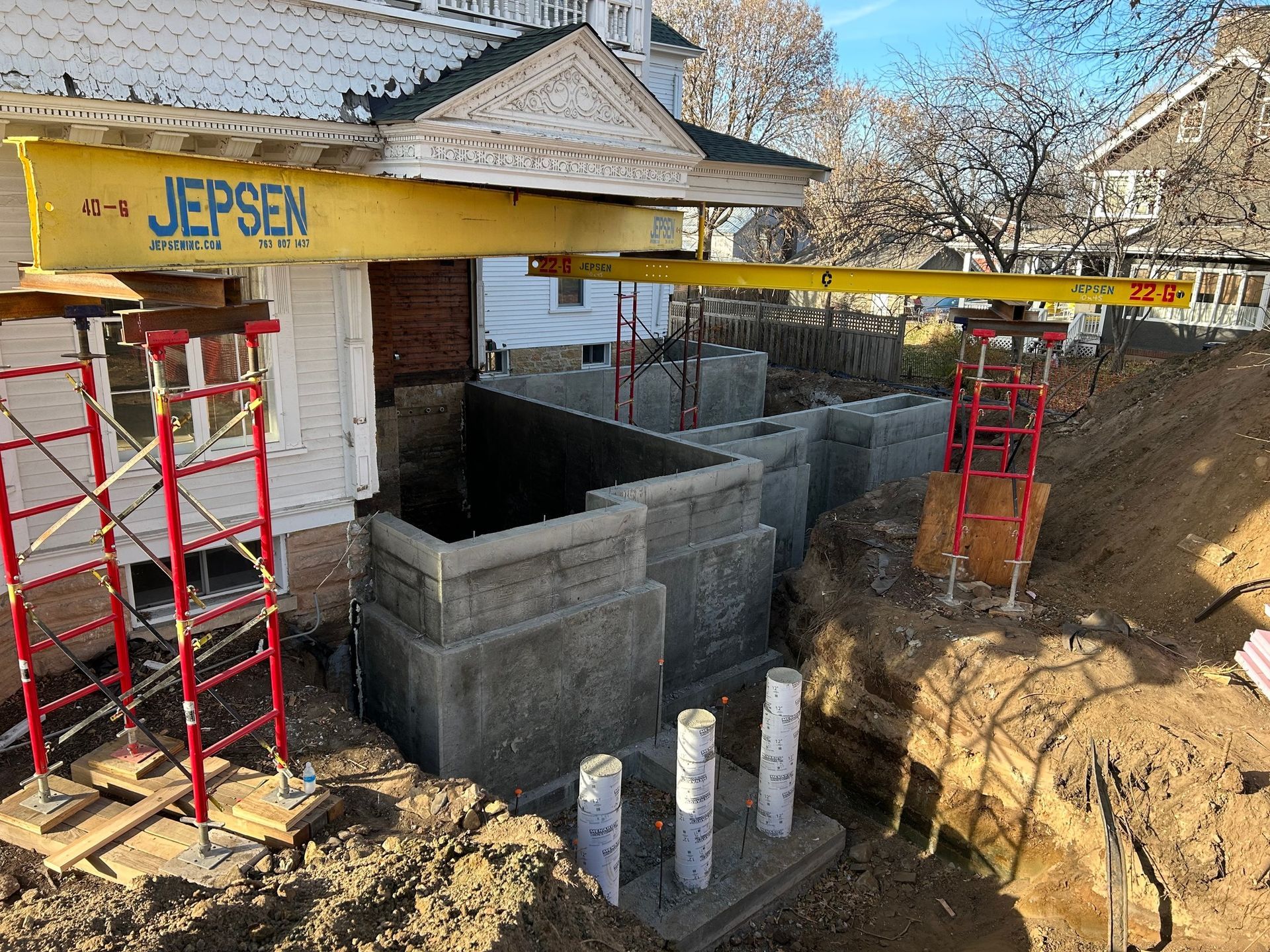 A yellow crane is being used to lift a house.
