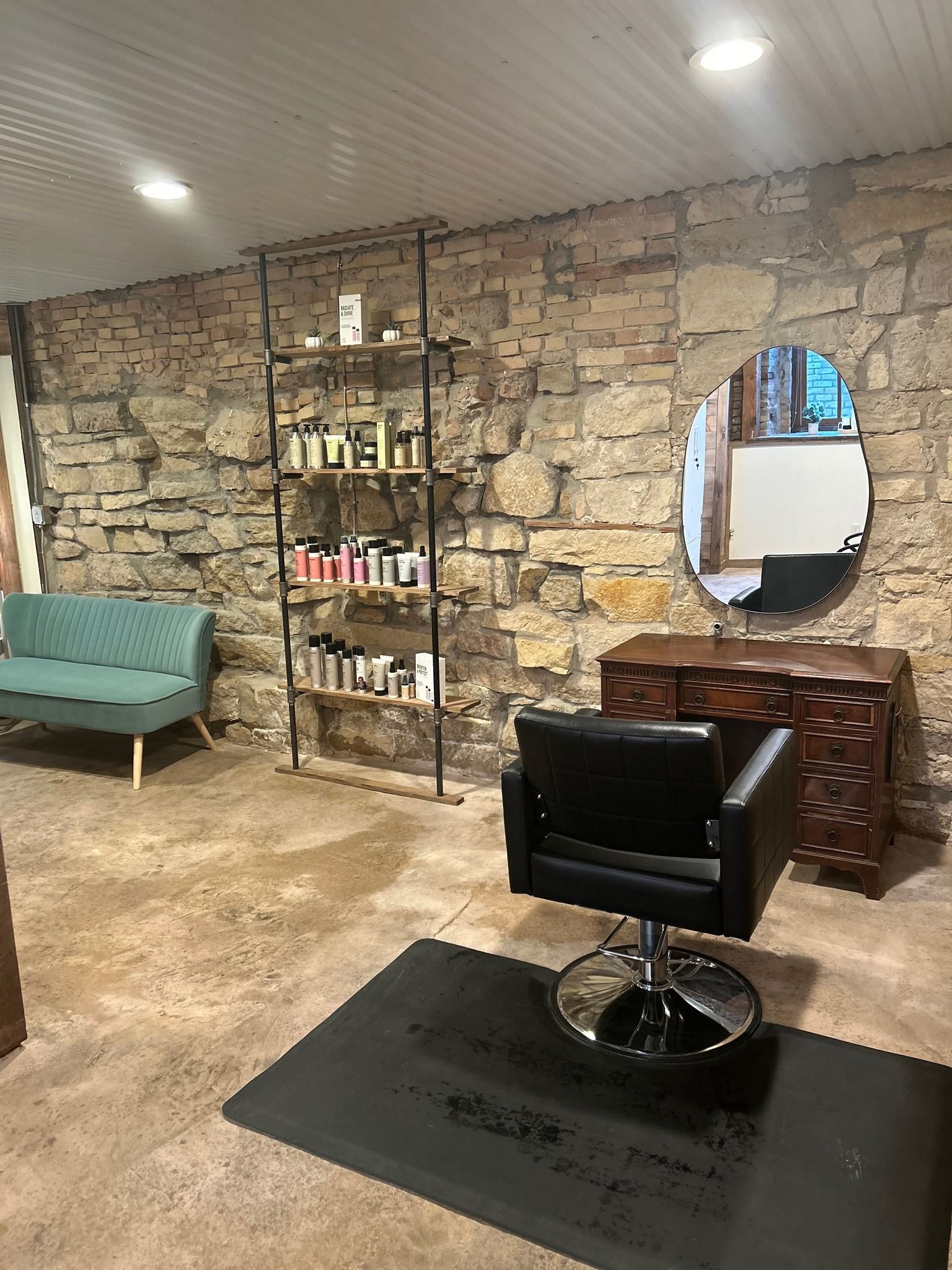 There is a chair in the middle of the room in a hair salon.