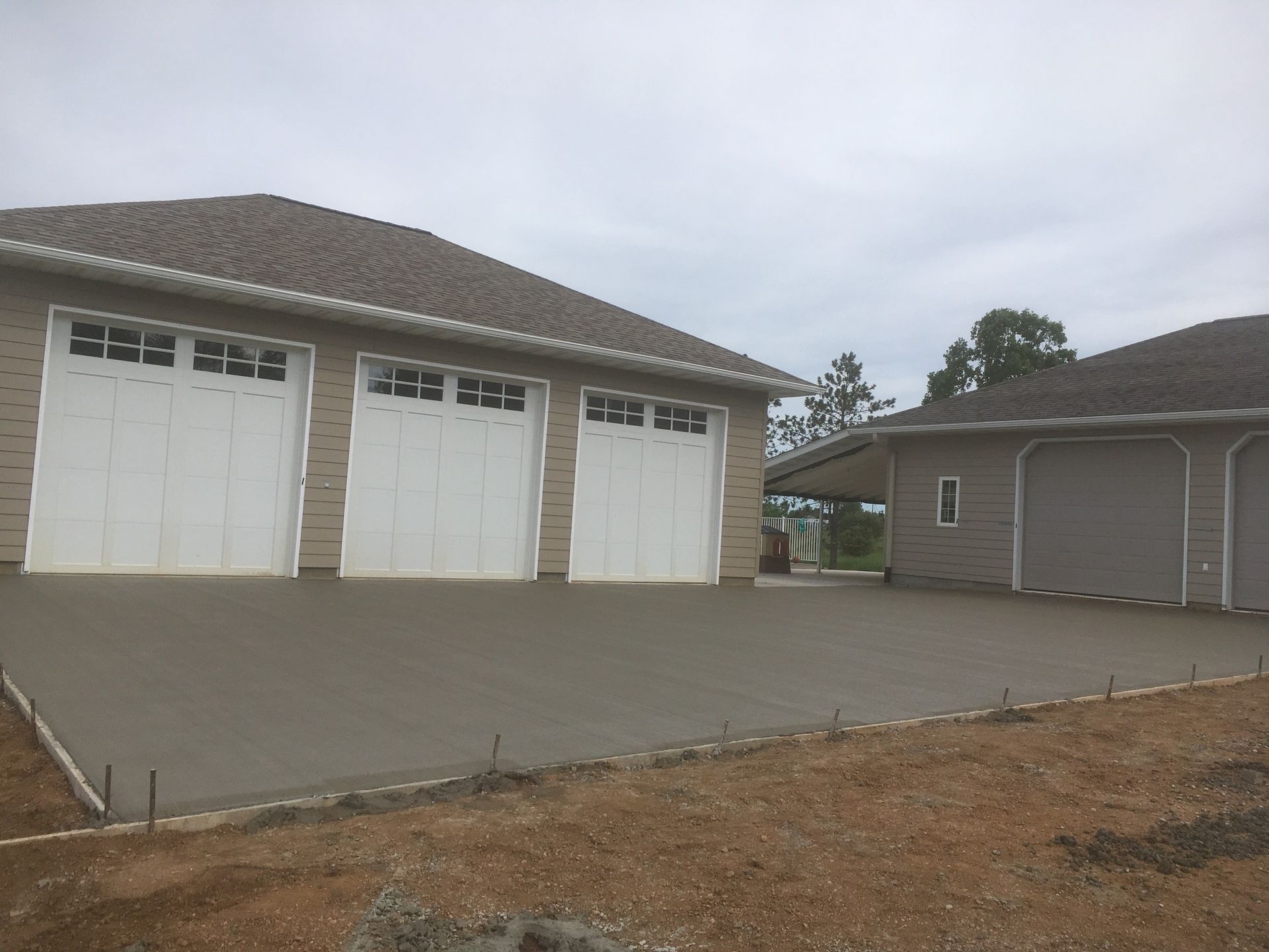 A house with three garage doors and a concrete driveway