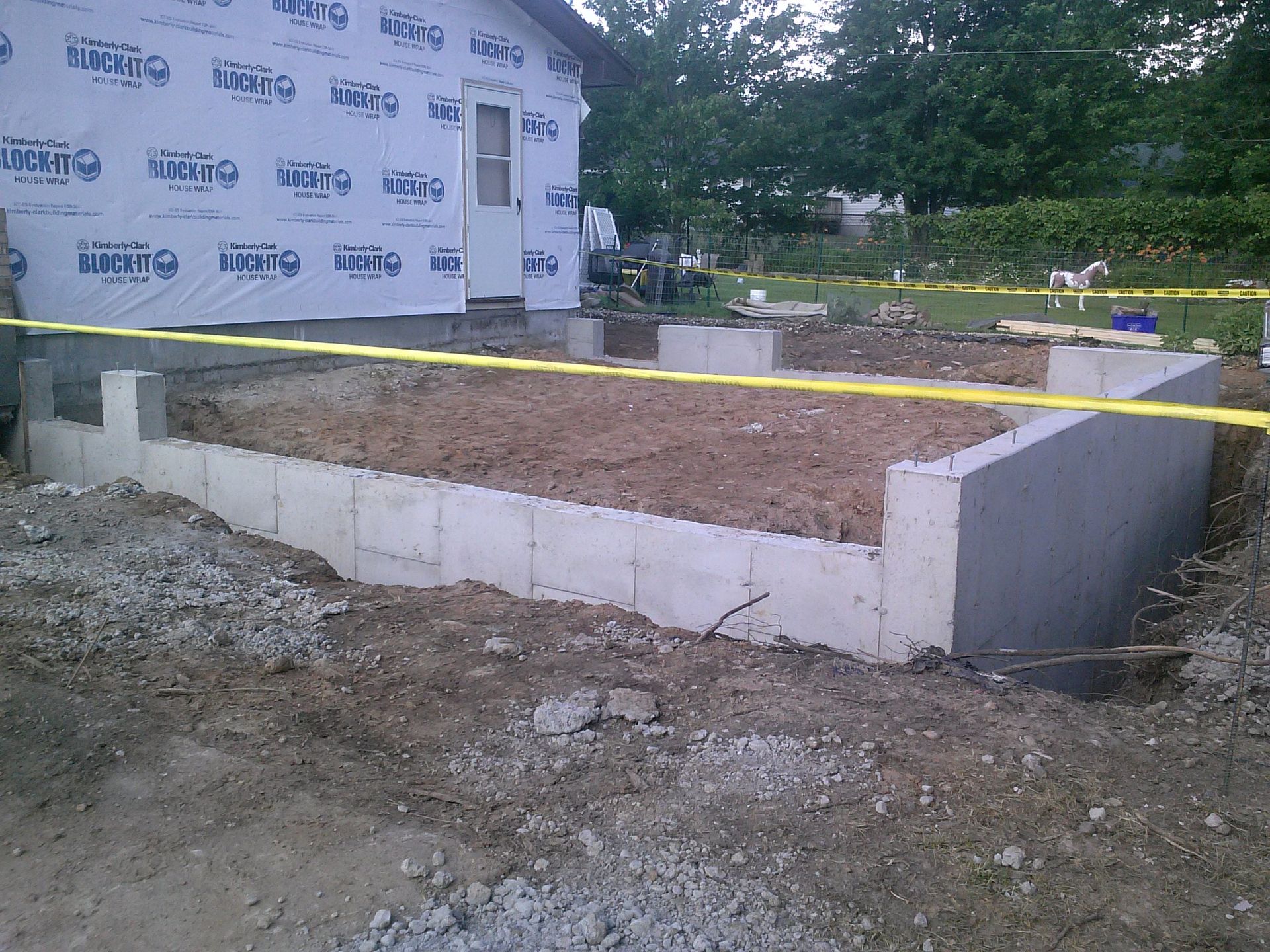 A concrete foundation is being built in front of a house