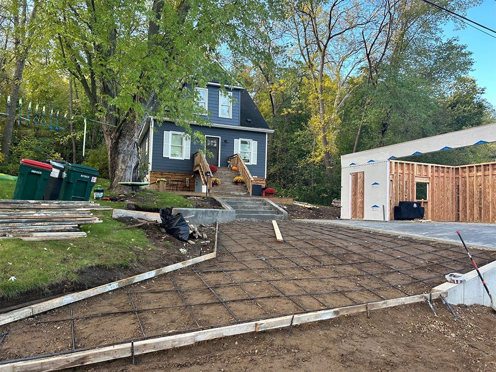 A house is being built next to a concrete driveway.