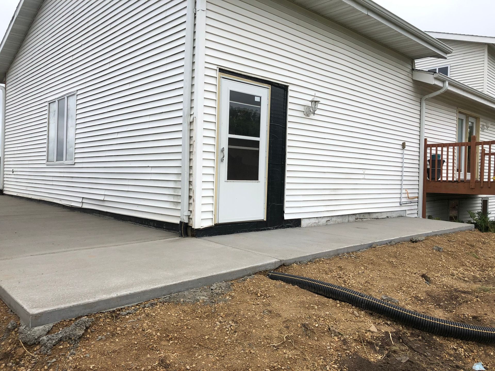 A white house with a concrete walkway leading to the door.
