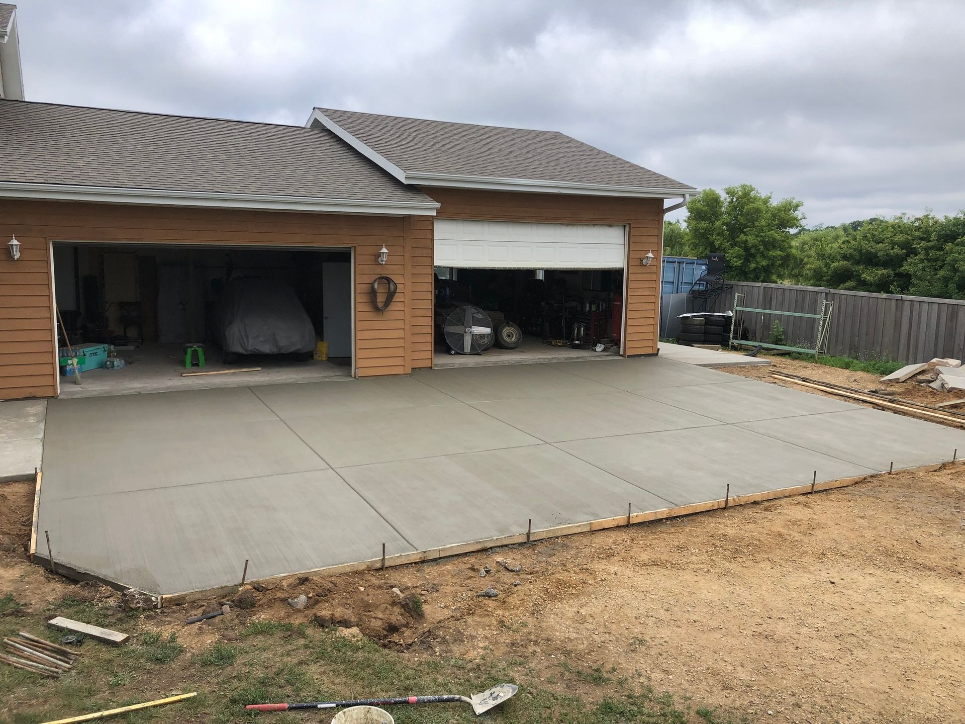 A concrete driveway is being built in front of a house.