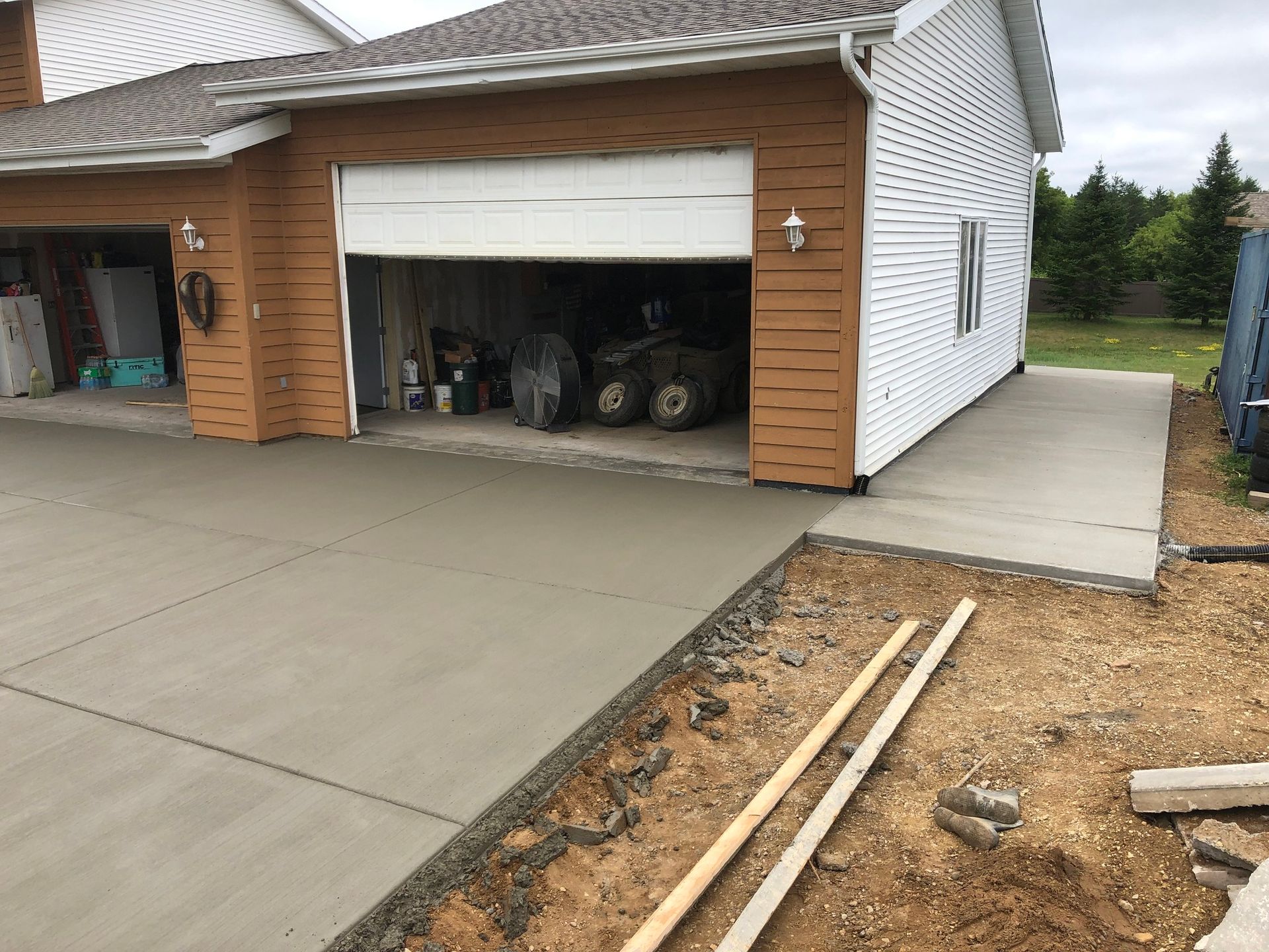 A house with a garage and a concrete driveway in front of it.