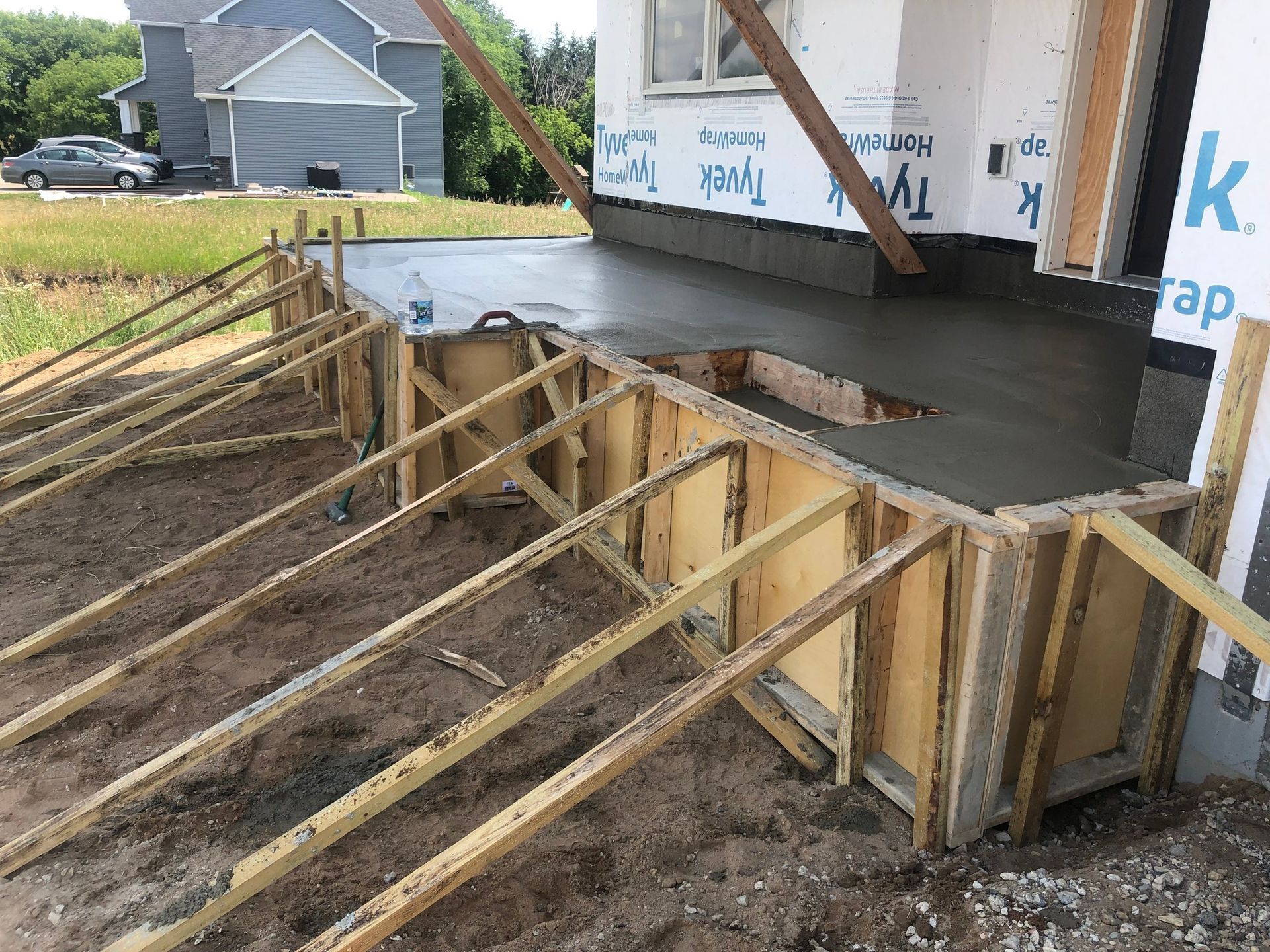A concrete walkway is being built in front of a house.