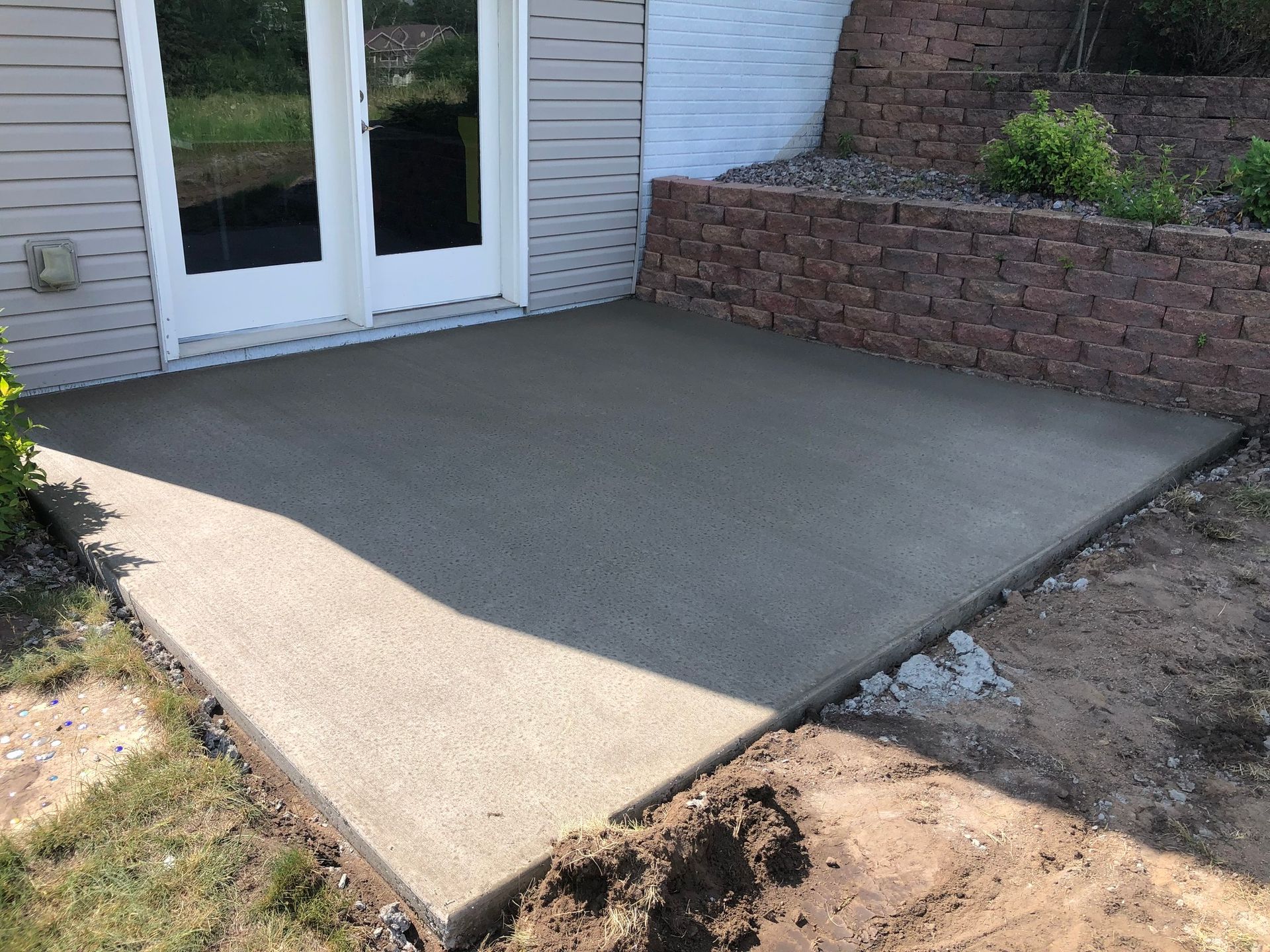 A concrete patio is being built in front of a house.